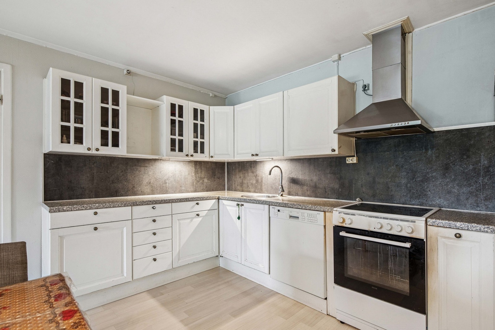 Kjøkkenet har klassiske, hvite profilerte fronter og belegg mellom benkeplate og overskap. Galleribilde