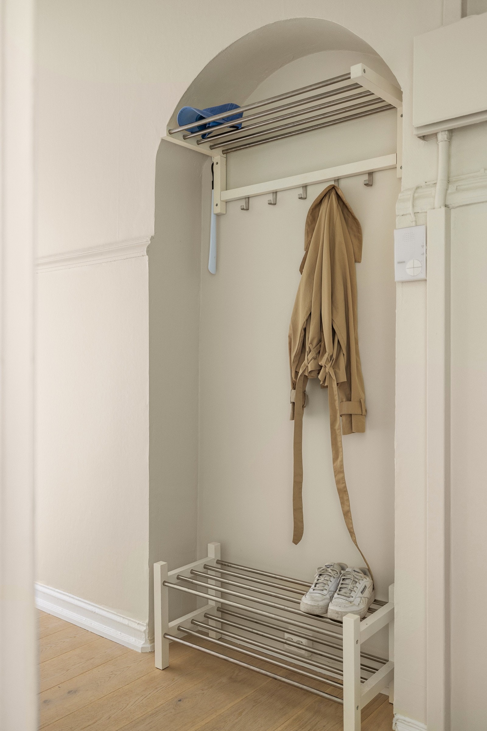 I en nydelig buet nisje har du plass til sko og oppheng av yttertøy. Montert porttelefon og sikringsskap med automatsikringer på vegg. Galleribilde