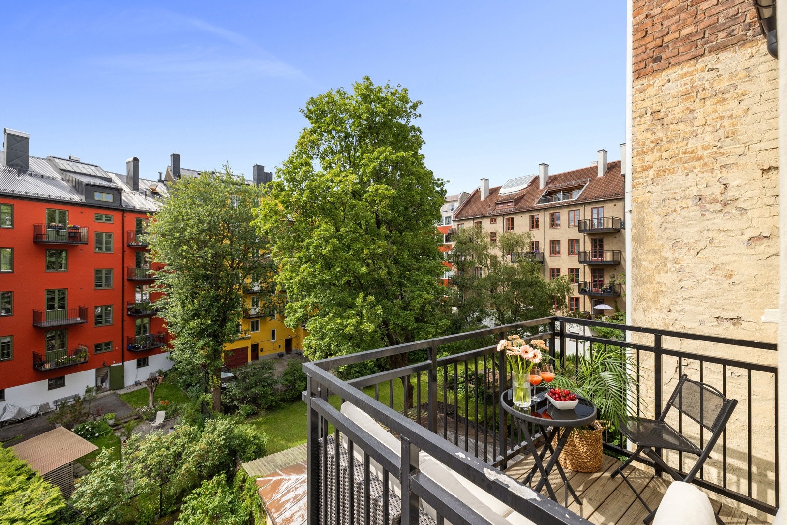 Hyggelig utsyn over den koselige bakhagen med frodig beplantning. Galleribilde