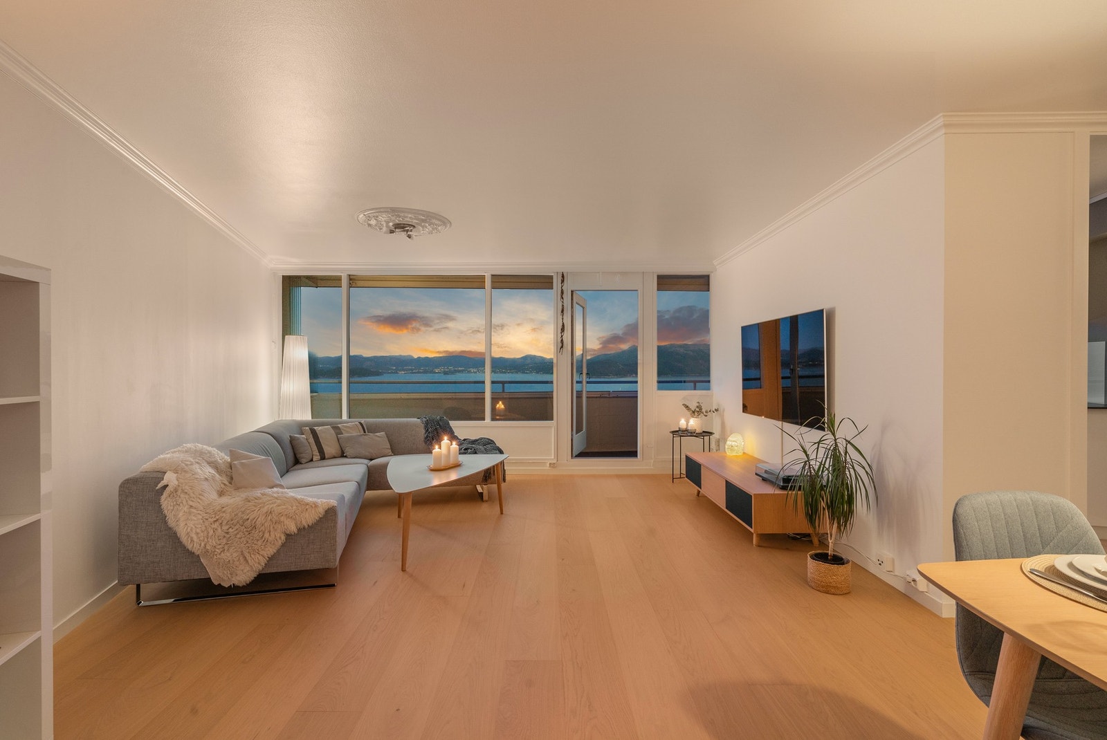 Romslig stue som enkelt lar seg møblere i ulike soner, med spise- og sittegruppe. Galleribilde