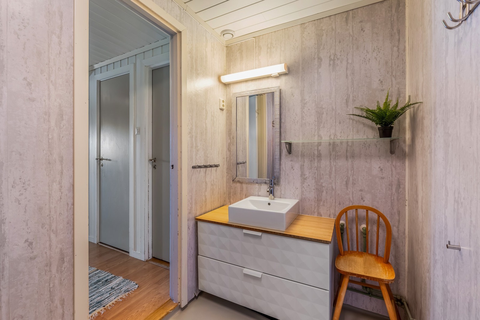 Rommet er utstyrt med dusjkabinett og en enkel baderomsinnredning med vask. Galleribilde