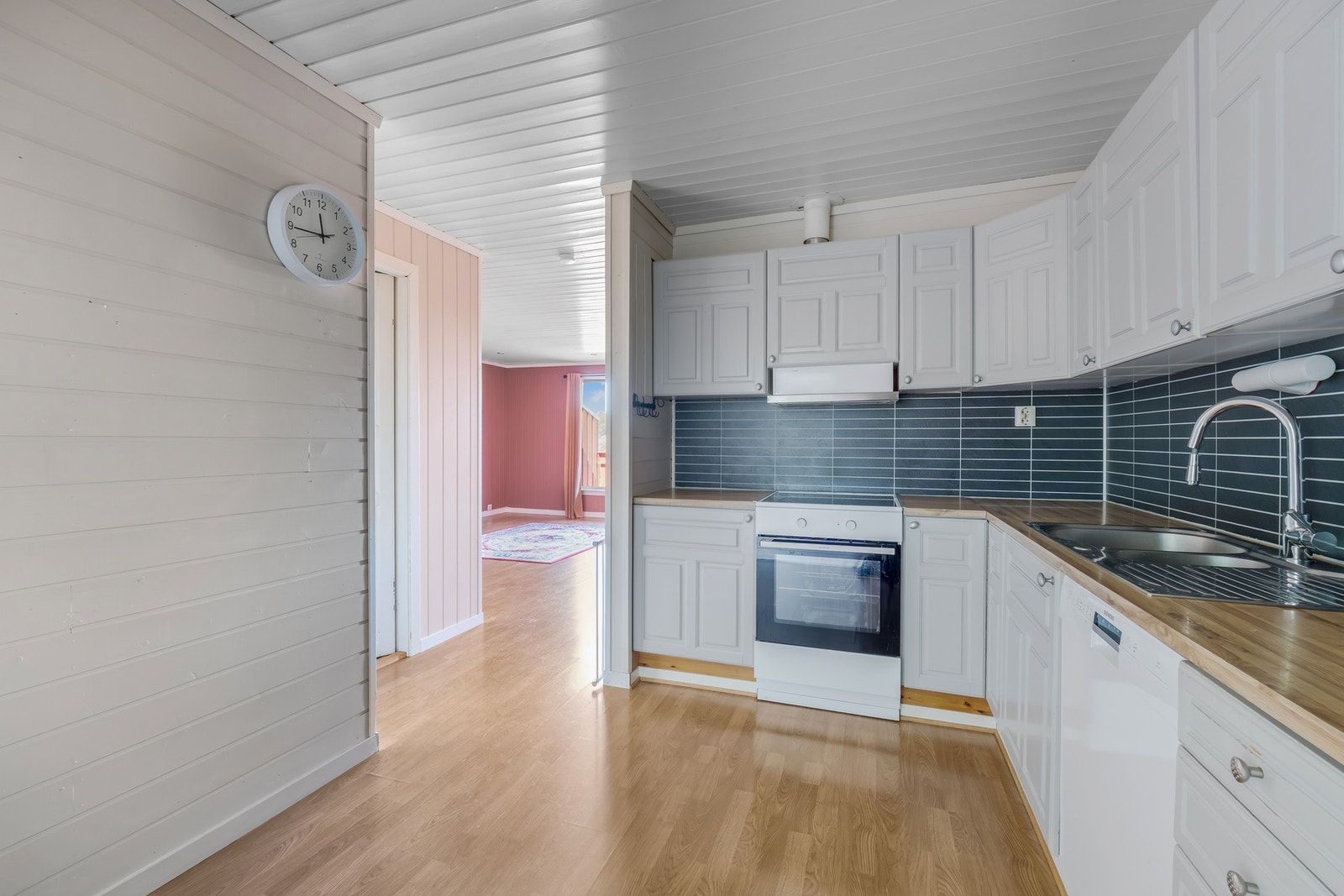 Kjøkkenet har en praktisk layout med folierte skrog og profilerte fronter som gir gode oppbevaringsmuligheter. Galleribilde