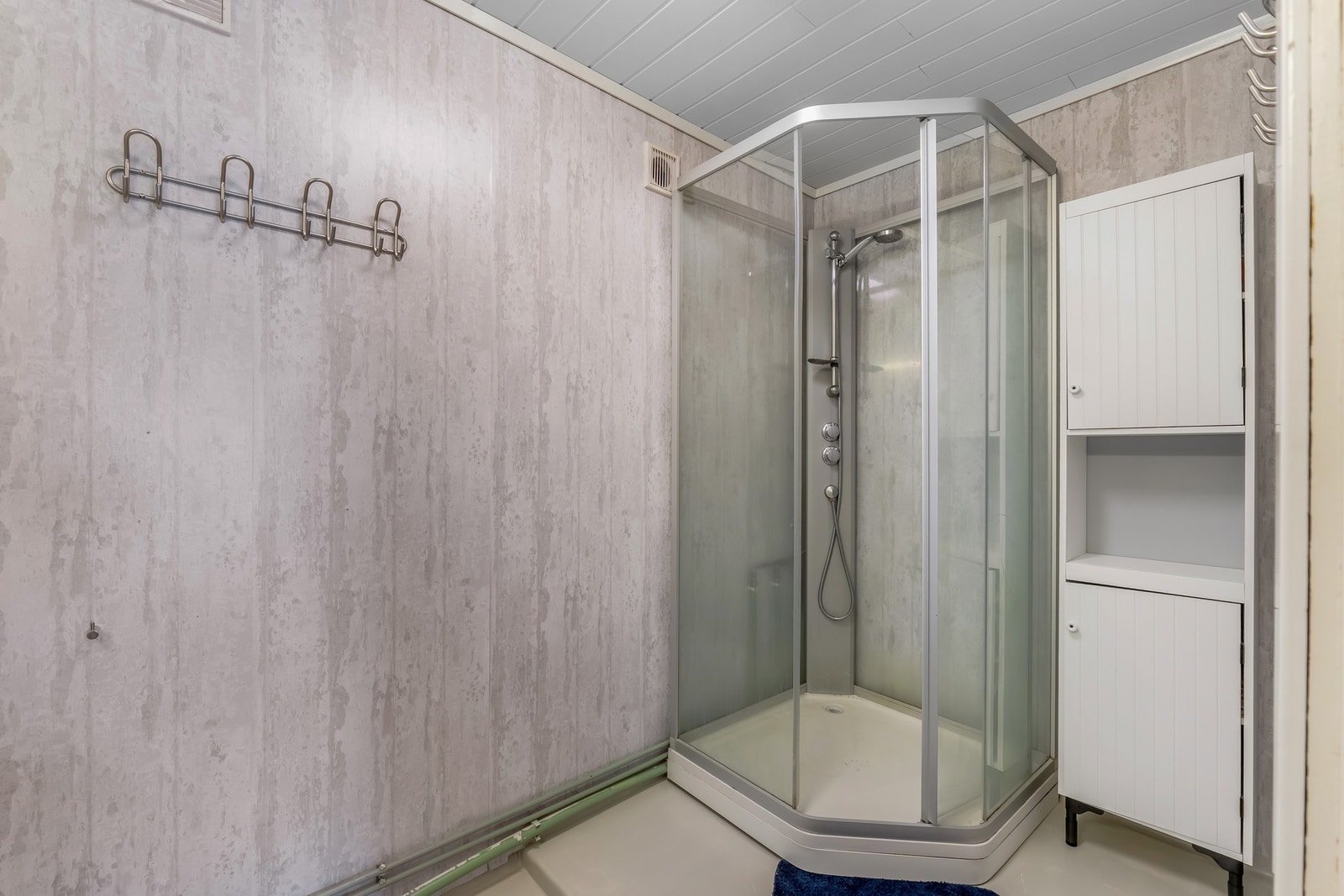 Badet i underetasjen har gulv med våtromsbelegg, vegger kledd med tapet og himling av trepanel. Galleribilde