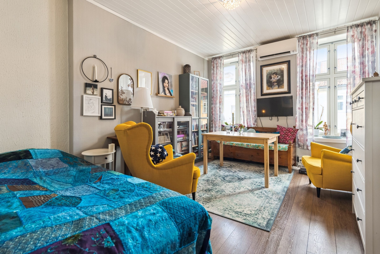 Stuen er lys og trivelig med takhøye vinduer og plass til både sofa og spisebord. Galleribilde