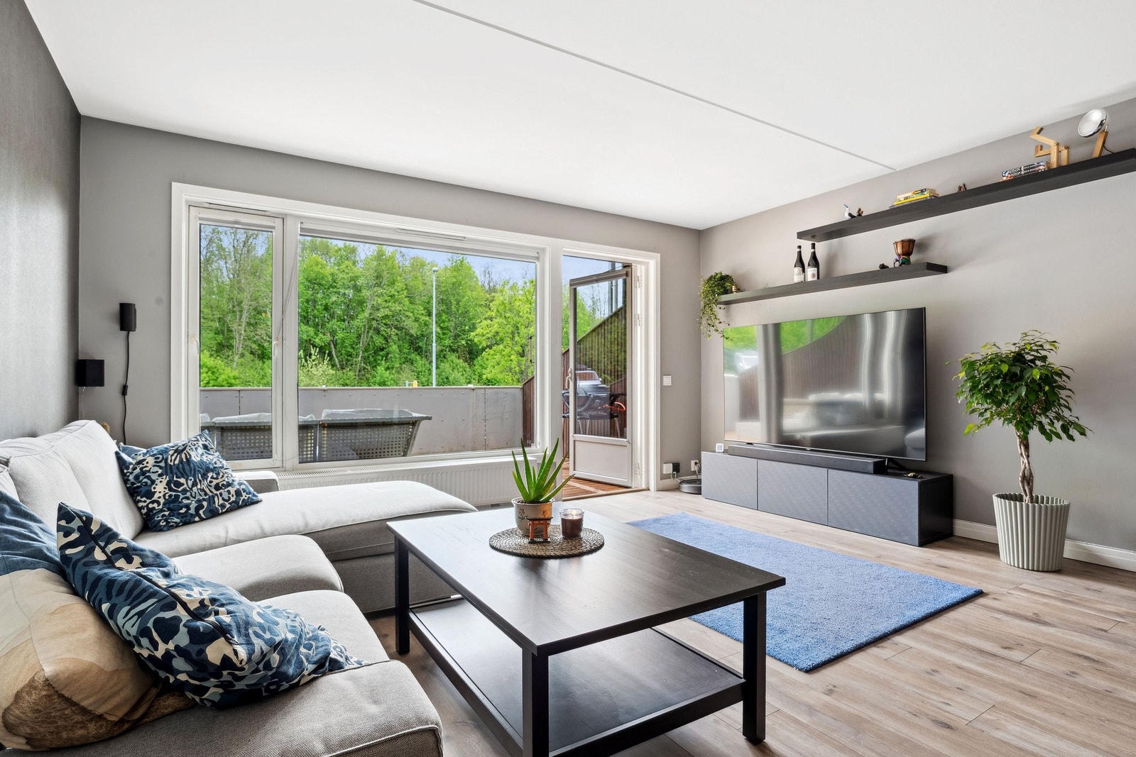 Stor stue og romselig stue som utgjør en praktisk og koselig sofakrok med TV. Galleribilde