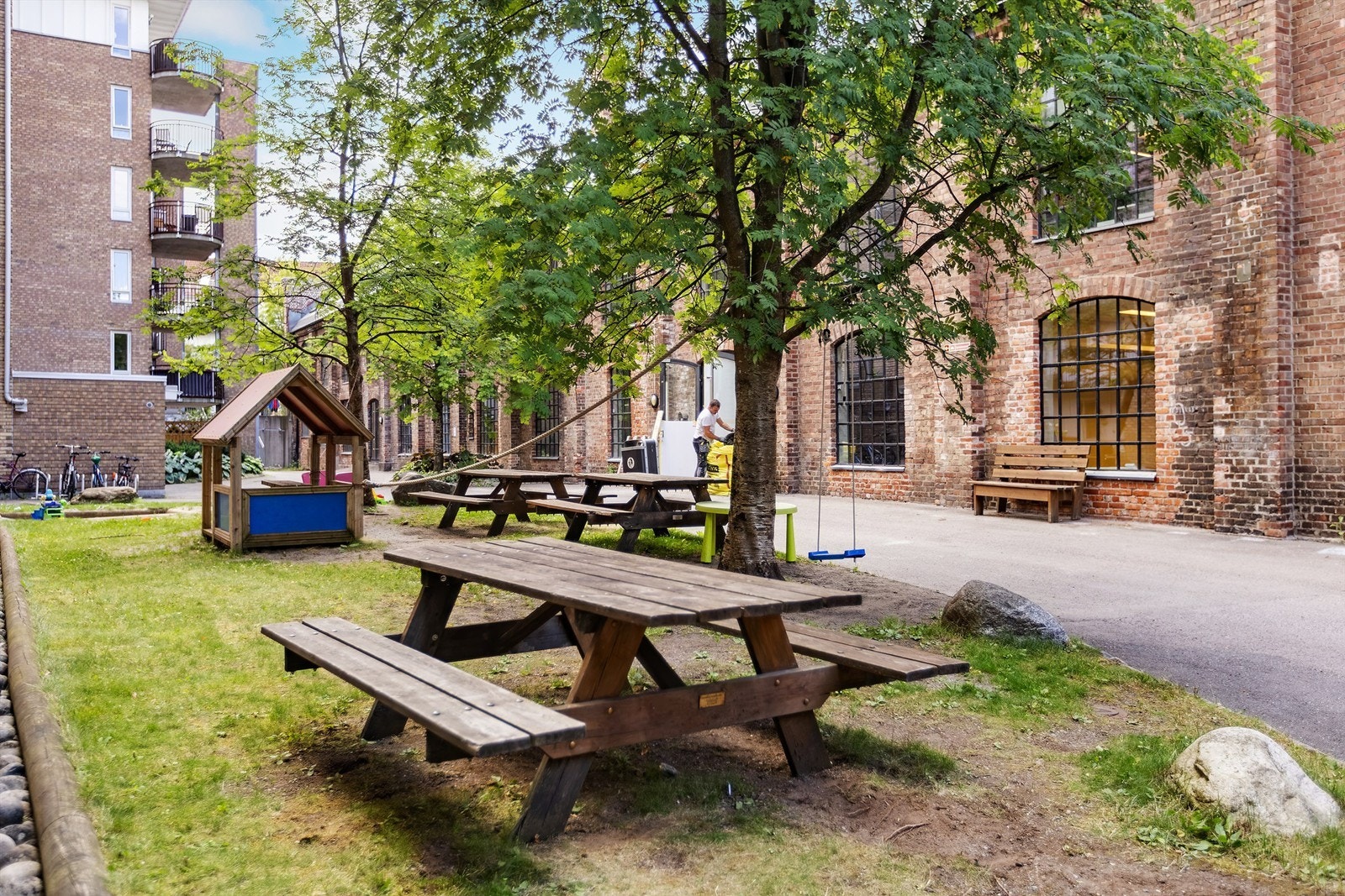 Koselig bakgård med grøntbeplantning og sittegrupper. Galleribilde