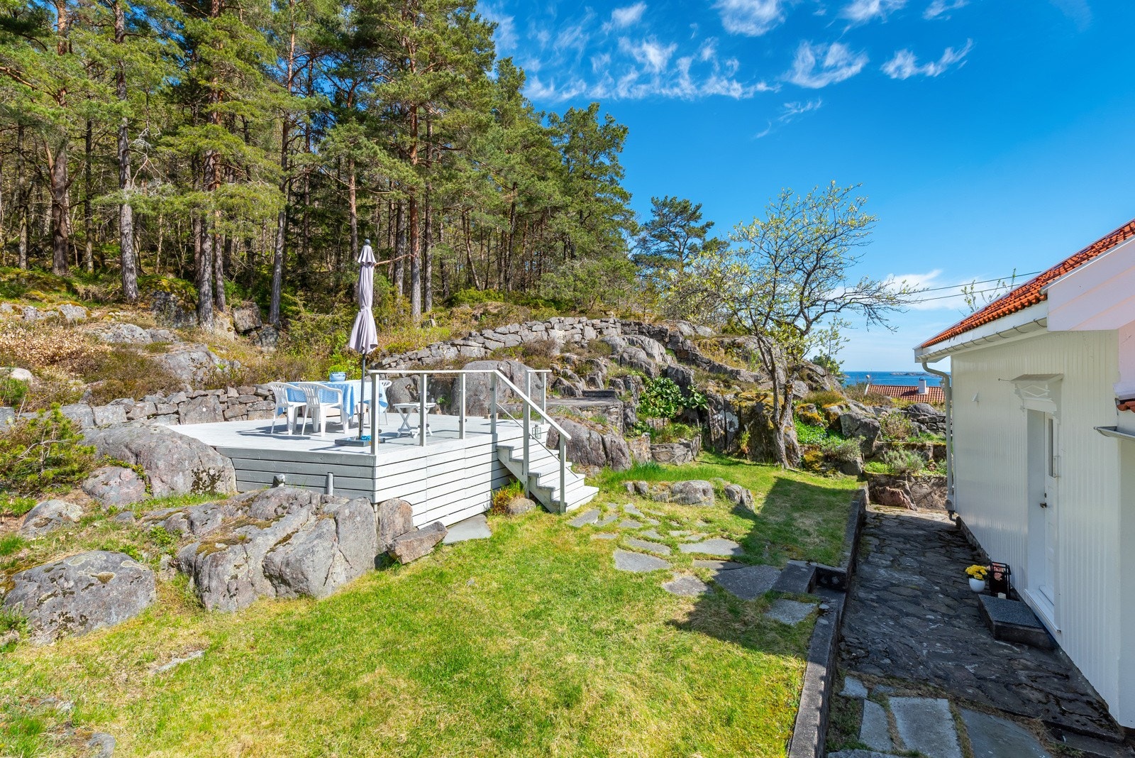 Eiendommen er delvis naturtomt, mens hagen er pent opparbeidet med plenareal og platting. Galleribilde