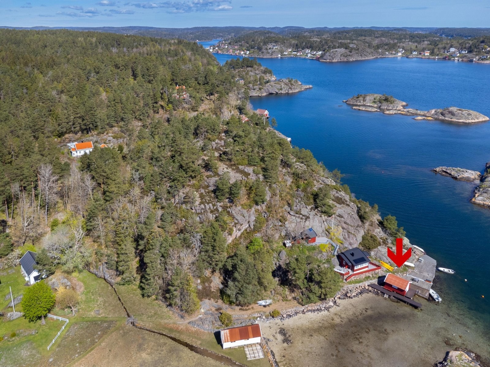 Du ser fritidsboligen øverst til venstre i bildet, og sjøbu med brygge nederst til høyre i bildet. Galleribilde