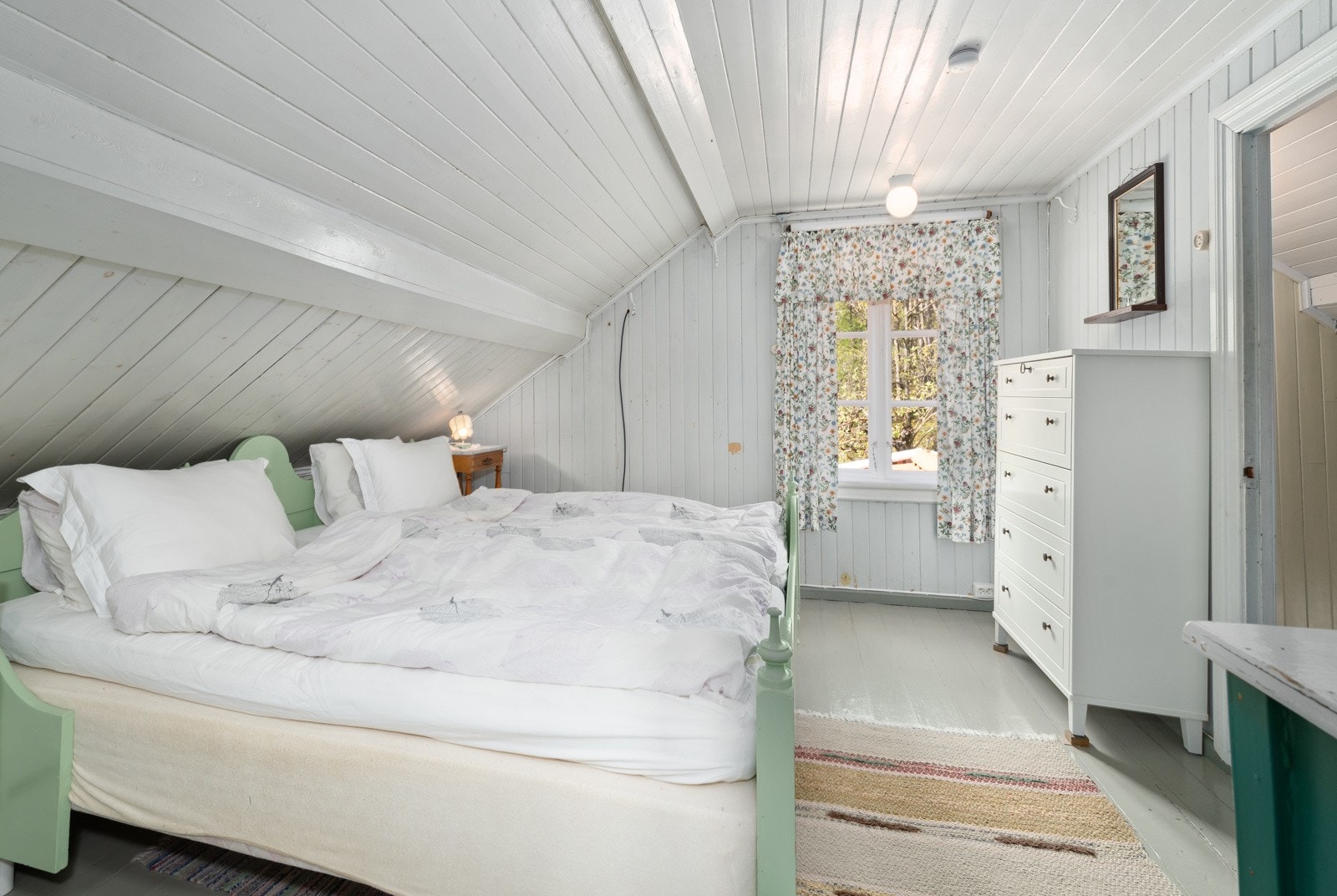 Soverom i loftsetasjen med god plass til dobbeltseng, nattbord på hver side og annet møblement for klesoppbevaring. Galleribilde