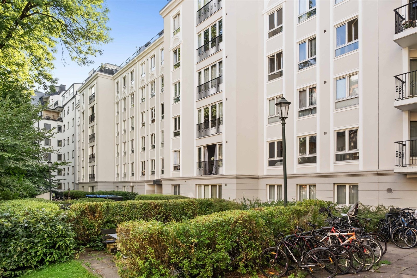 Pent opparbeidet bakgård med flere sittegrupper og sykkelparkering Galleribilde