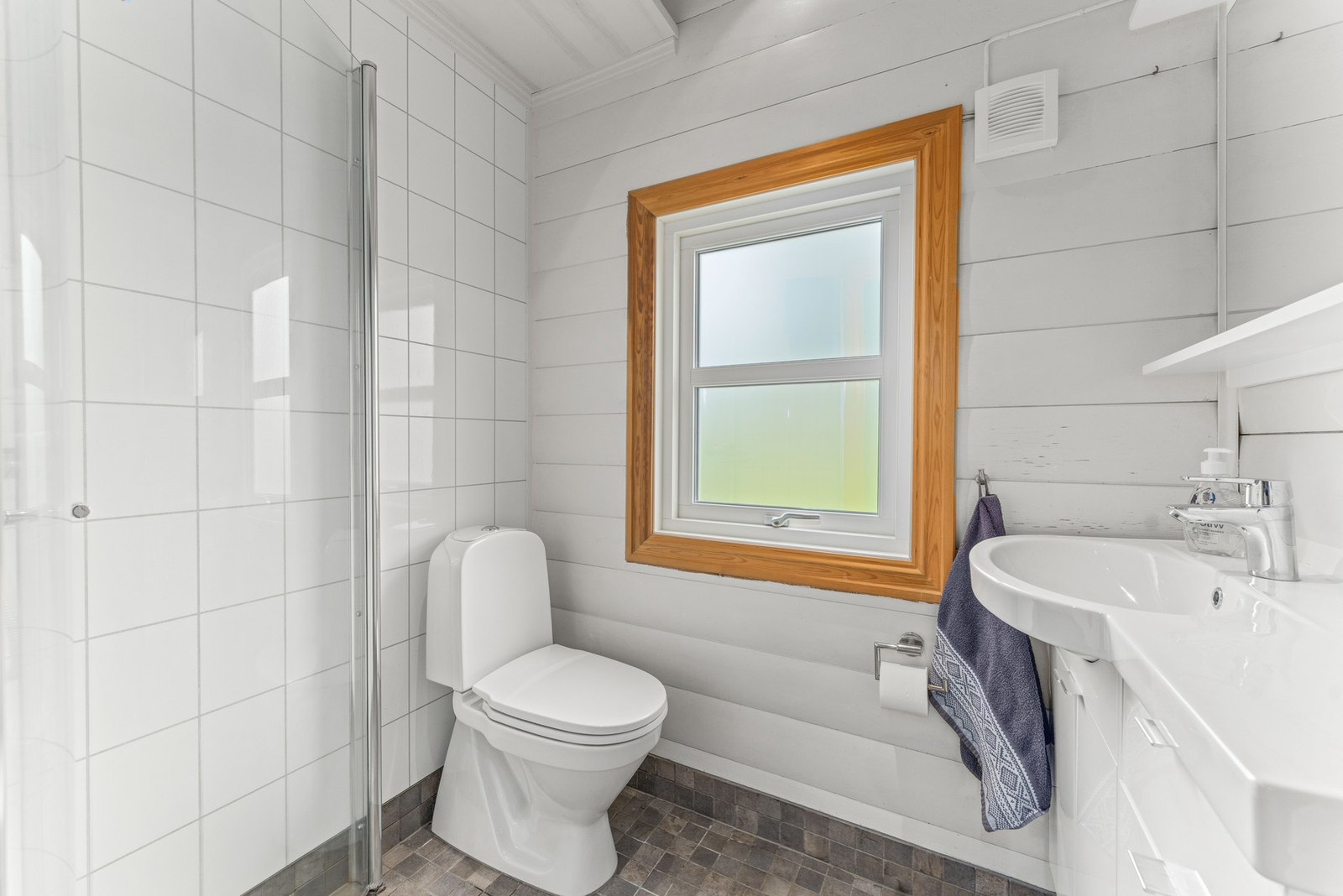 Det eldste badet ble renovert i 2010 og har laftede vegger kombinert med baderomsplater, dusjhjørne, servant og toalett. Galleribilde