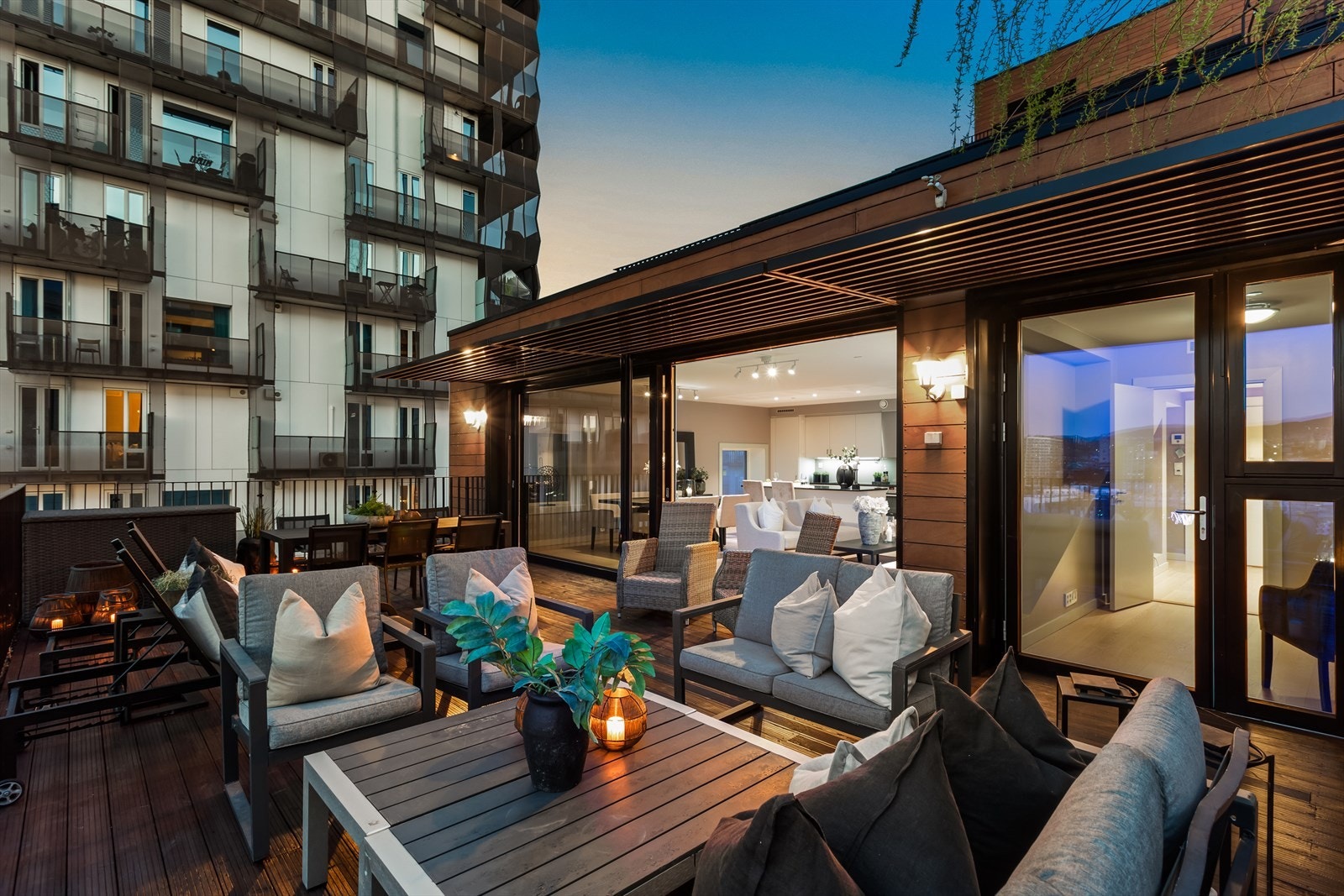 God plass til lounge, spisebord, grill, beplantning og folk Galleribilde