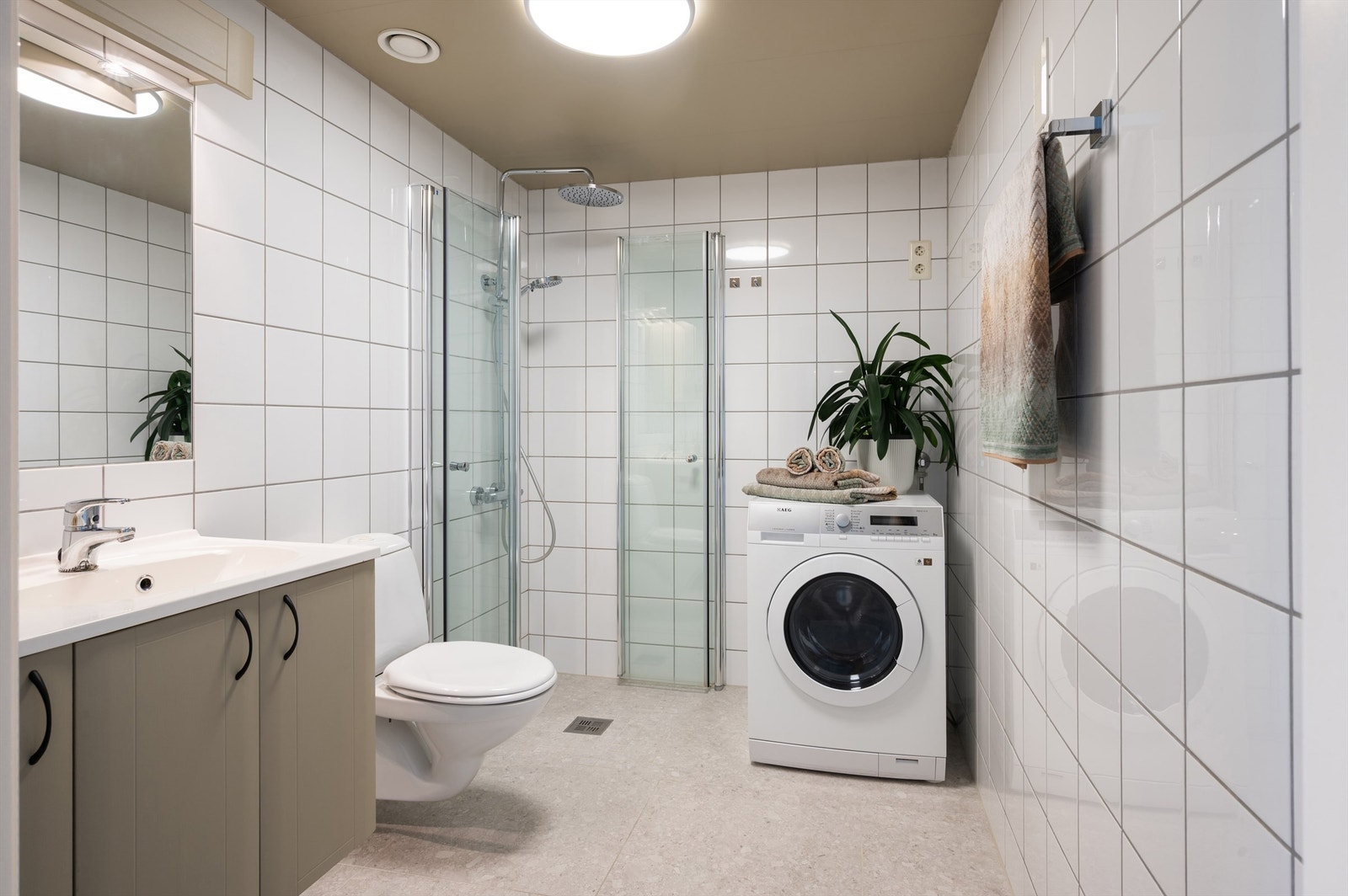 Romslig og delikat baderom med flislagte overflater. Vannbåren gulvvarme for en lun og behagelig start på dagen. Galleribilde