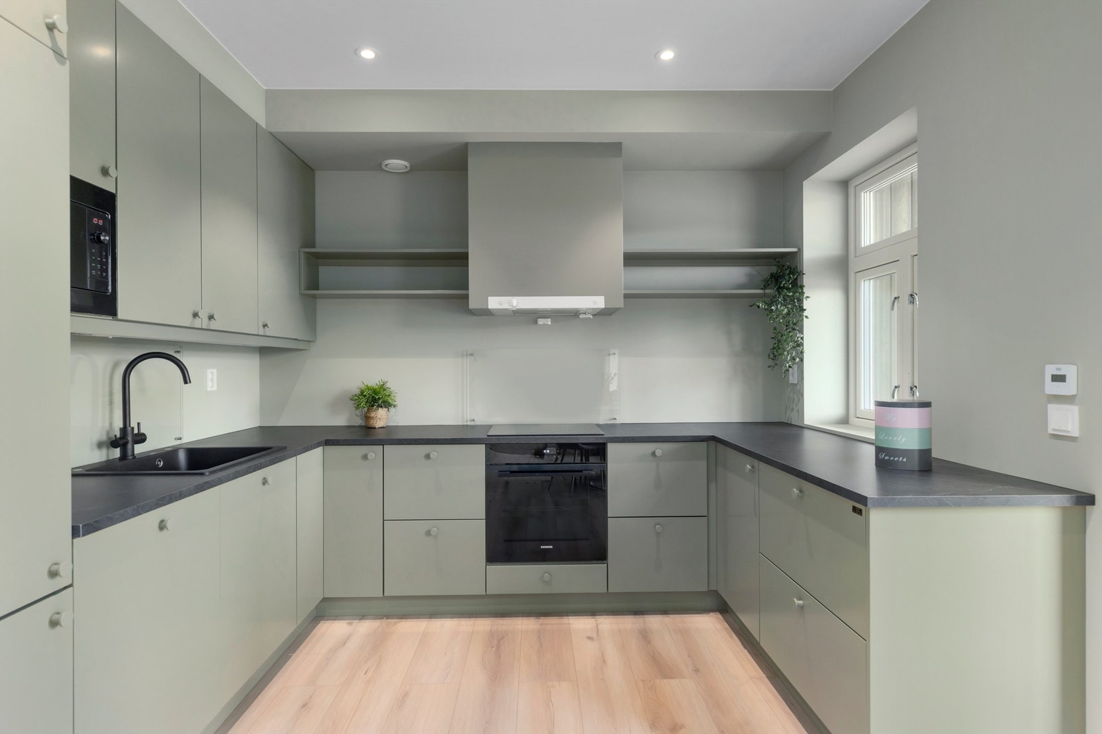 Kjøkkenet ligger naturlig tilbaketrukket fra stuen og er innredet med nydelig kjøkkeninnredning fra Fosen trapp og interiør. Galleribilde