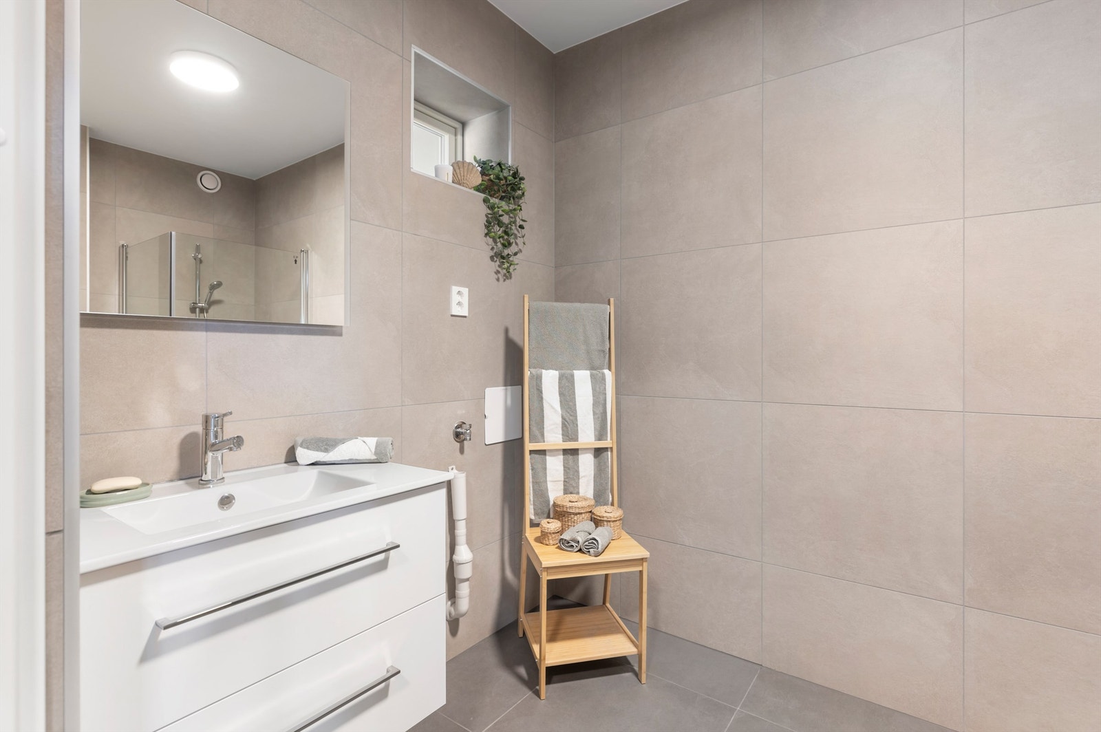 Leiligheten har pent flislagt bad med varme i gulv og opplegg for vaskemaskin. Galleribilde