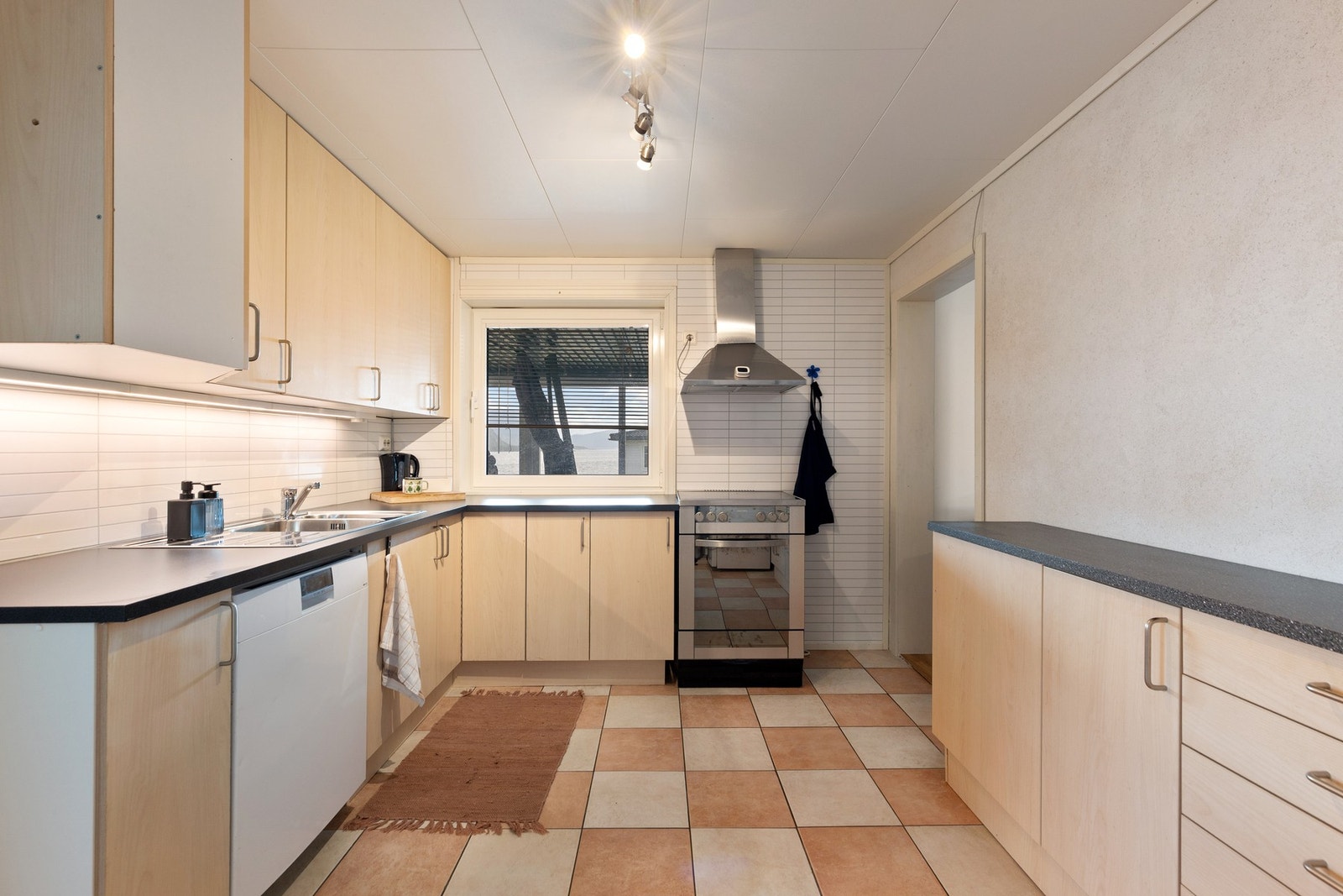 Kjøkkenet har innredning med glatte fronter og benkeplaten av laminat med overlimt vask. Galleribilde