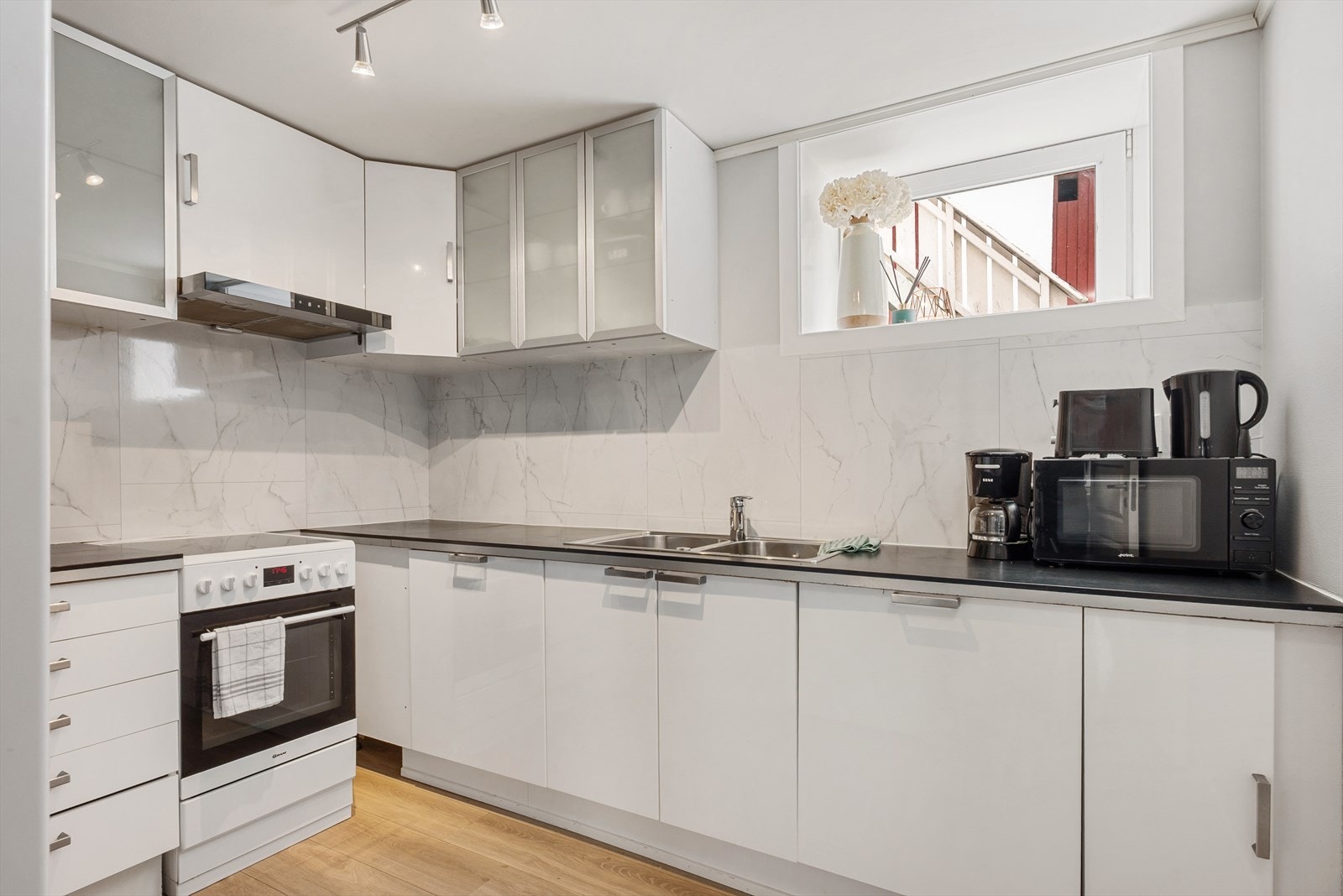 Kjøkkenet er funksjonelt plassert i en L-form og ligger adskilt fra stuen, men med åpen dør mot stue og gang. Galleribilde