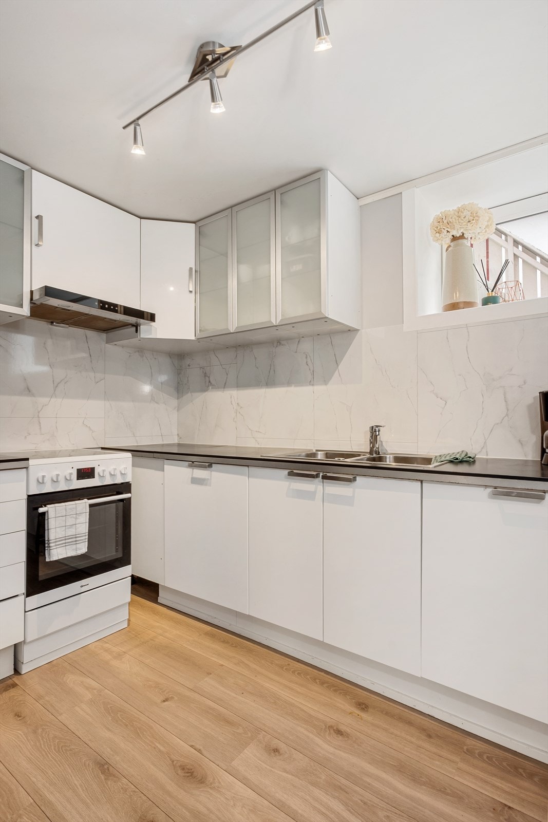 Innredning er tidløs med hvite fronter og benkeplate i laminat. Det er godt med skap og benkeplass, av hvitevarer er det integrert oppvaskmaskin og frittstående komfyr og kjøleskap. Galleribilde