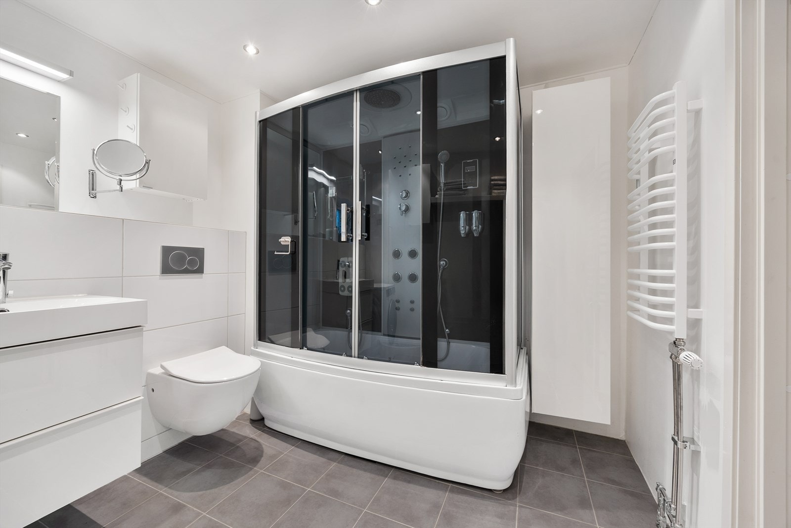 Badet har varmekabler i gulv og bærer et moderne design som står i stil med resten av leiligheten. Galleribilde