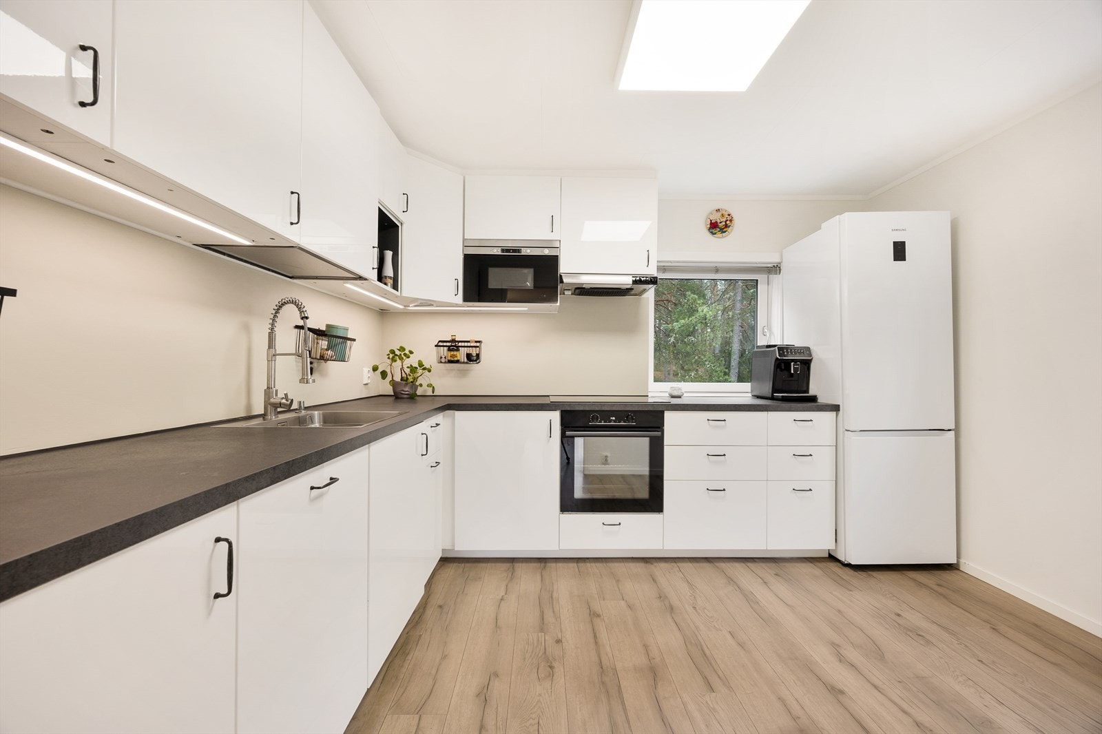 Kjøkkeninnredning med laminerte skrog og glatte fronter i et moderne og stilrent design. Galleribilde