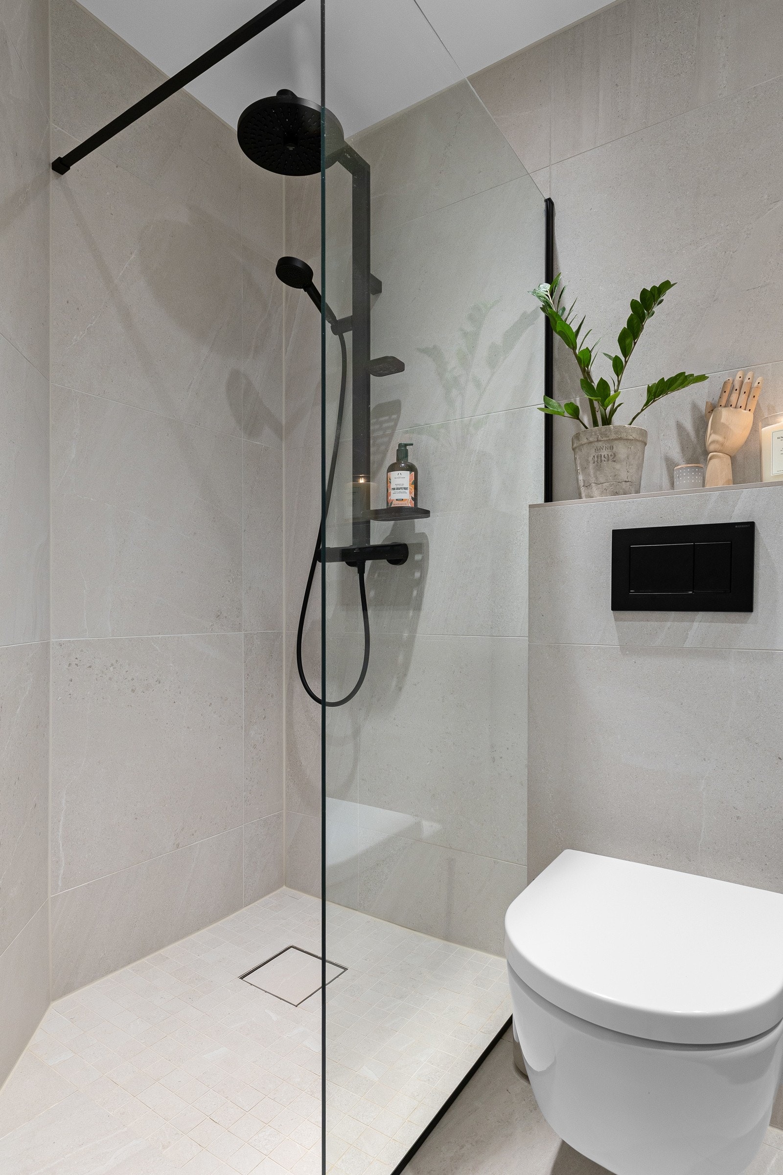 Badet er utstyrt med vegghengt toalett, nedsenket servant med moderne innredning og speil over. Galleribilde