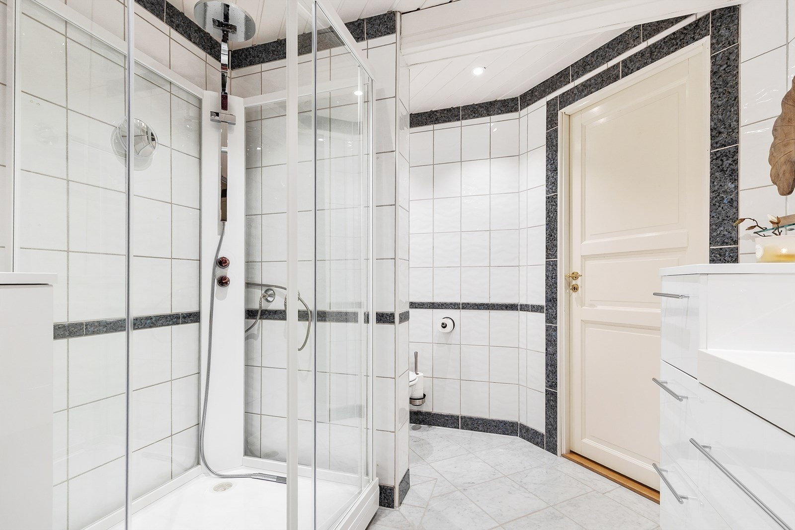 Badet er innredet med dusjkabinett, toalett og servant med flere skuffer for oppbevaring. Galleribilde