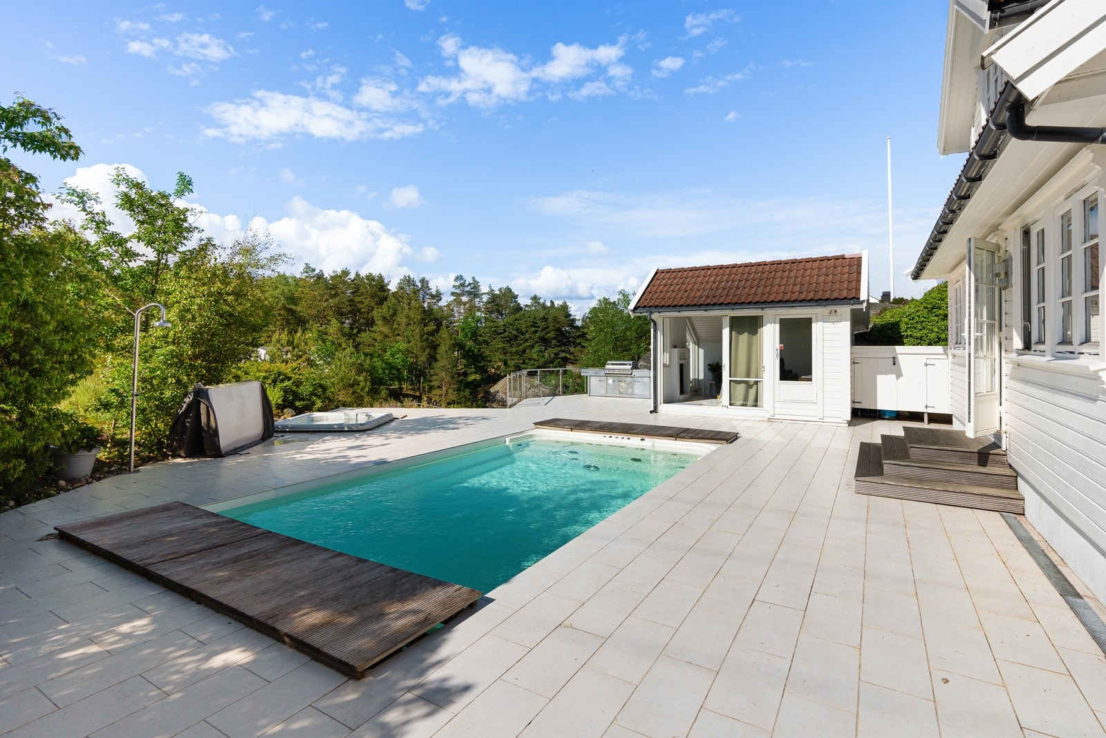 Uteområdene er flott opparbeidet med basseng, utestue og flislagt terrasse Galleribilde