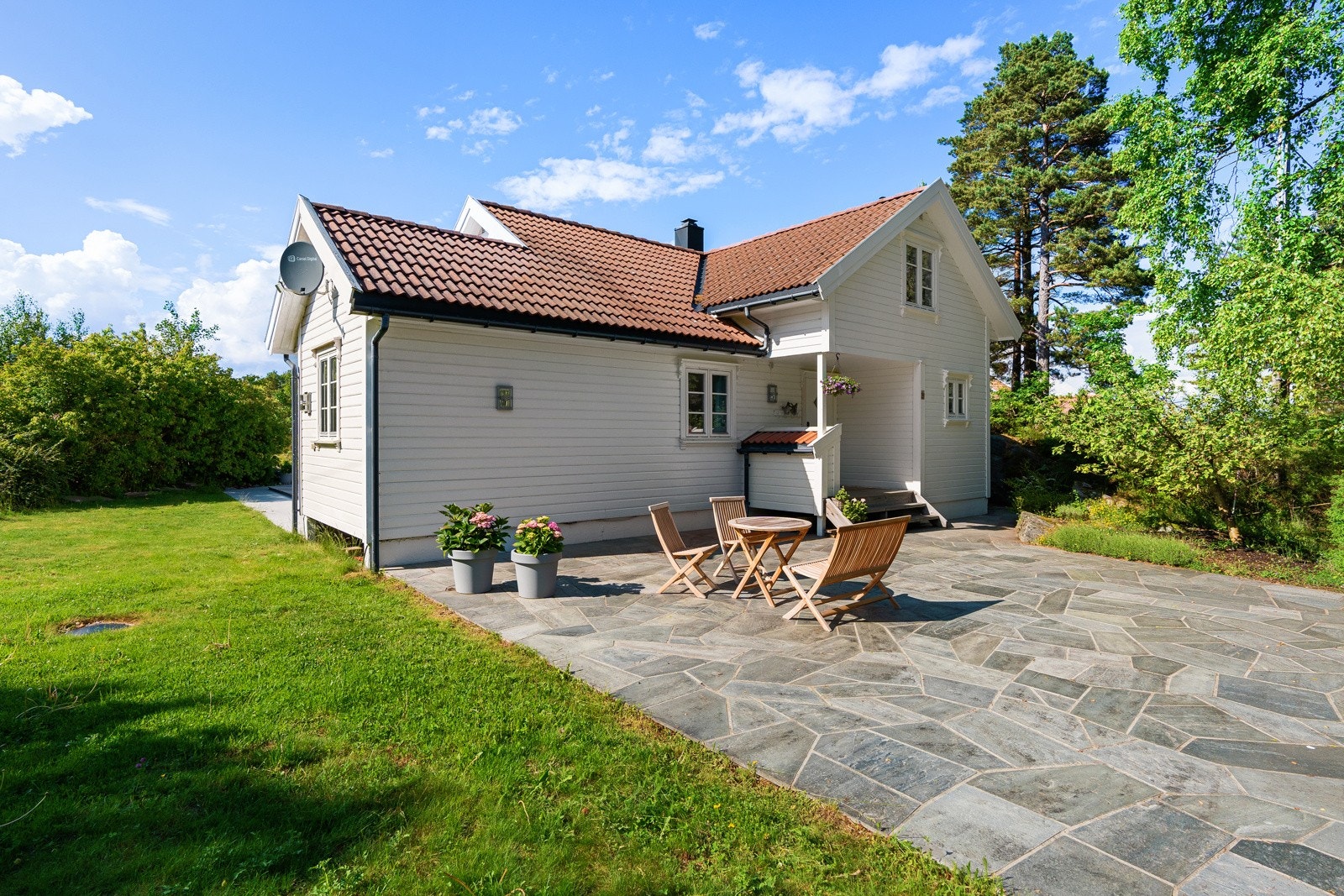 Inngangsparti med steinlagt terrasse med morgensol Galleribilde