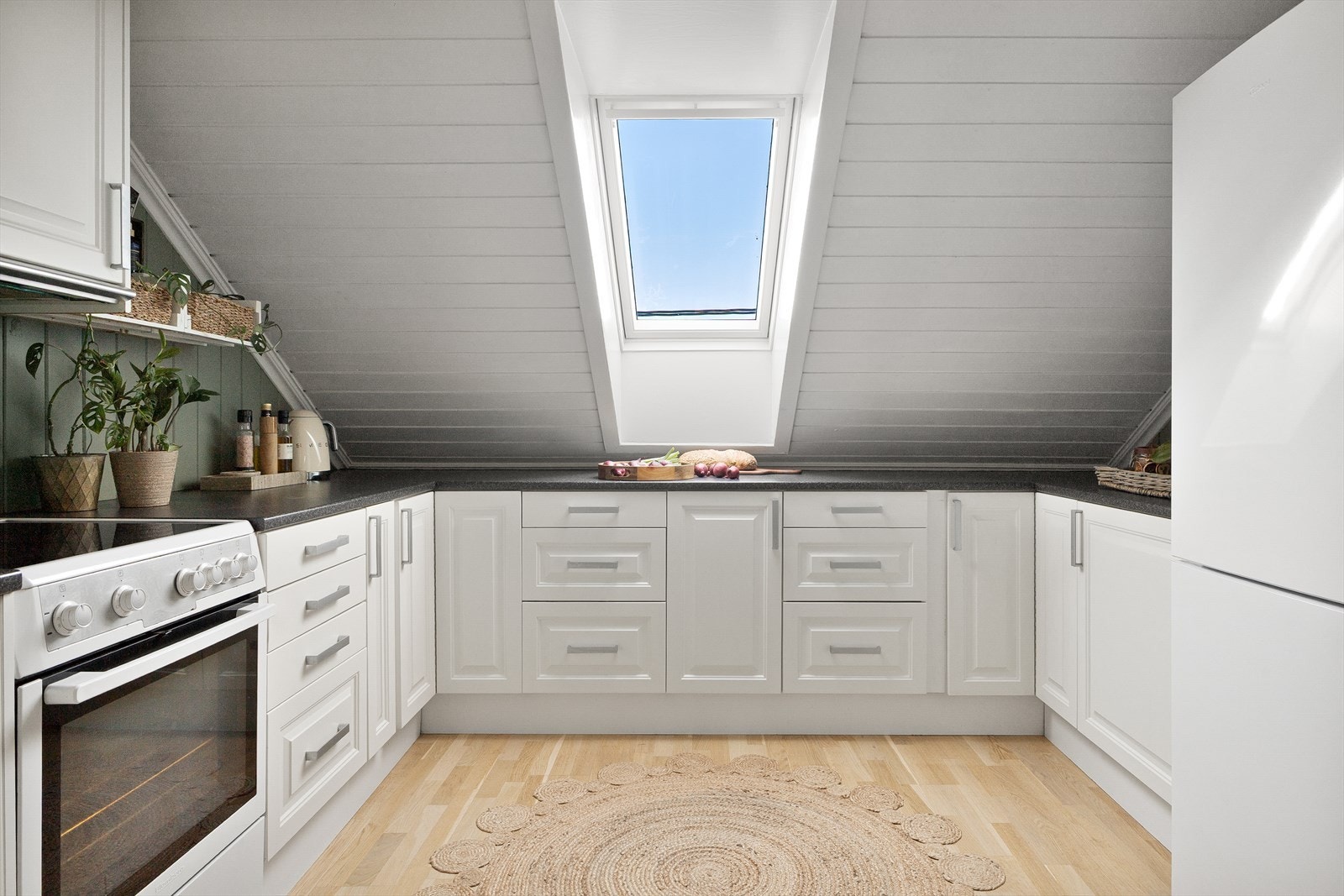 Lyst og praktisk kjøkken med profilerte fronter og laminert benkeplate. Galleribilde