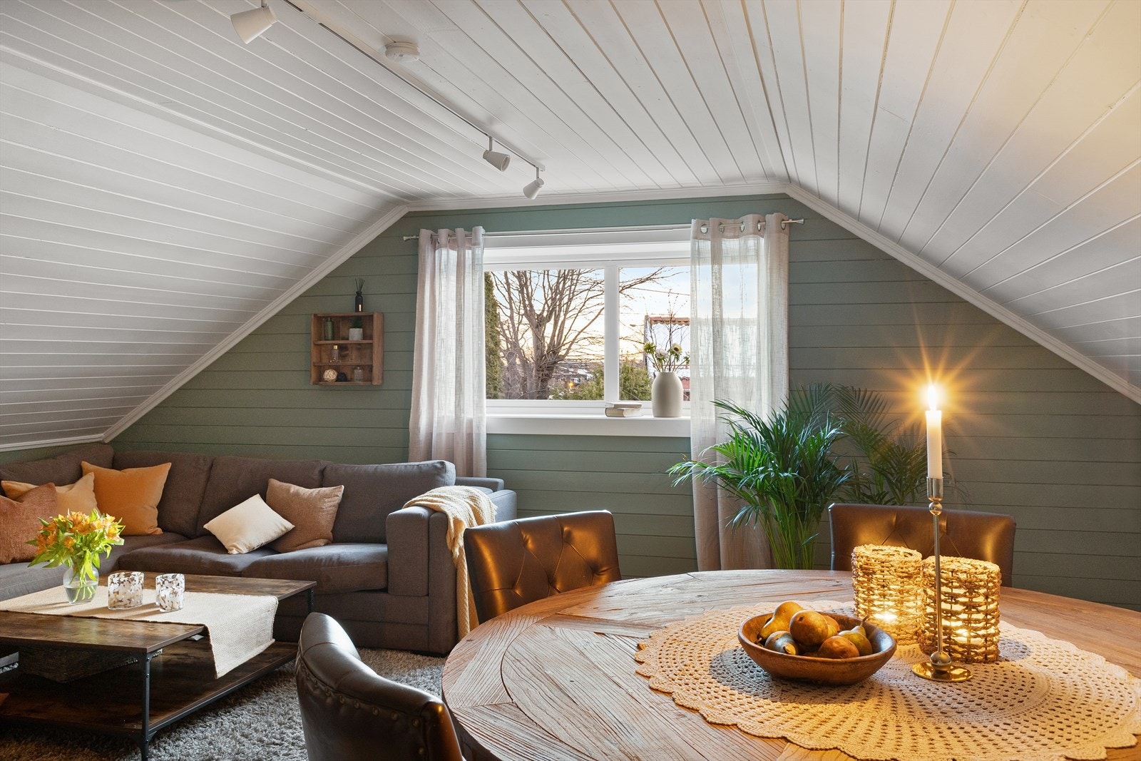 Hyggelig stue med store vindusflater og skråtak som skaper en lun atmosfære. God plass til både sofagruppe og spisebord. Galleribilde