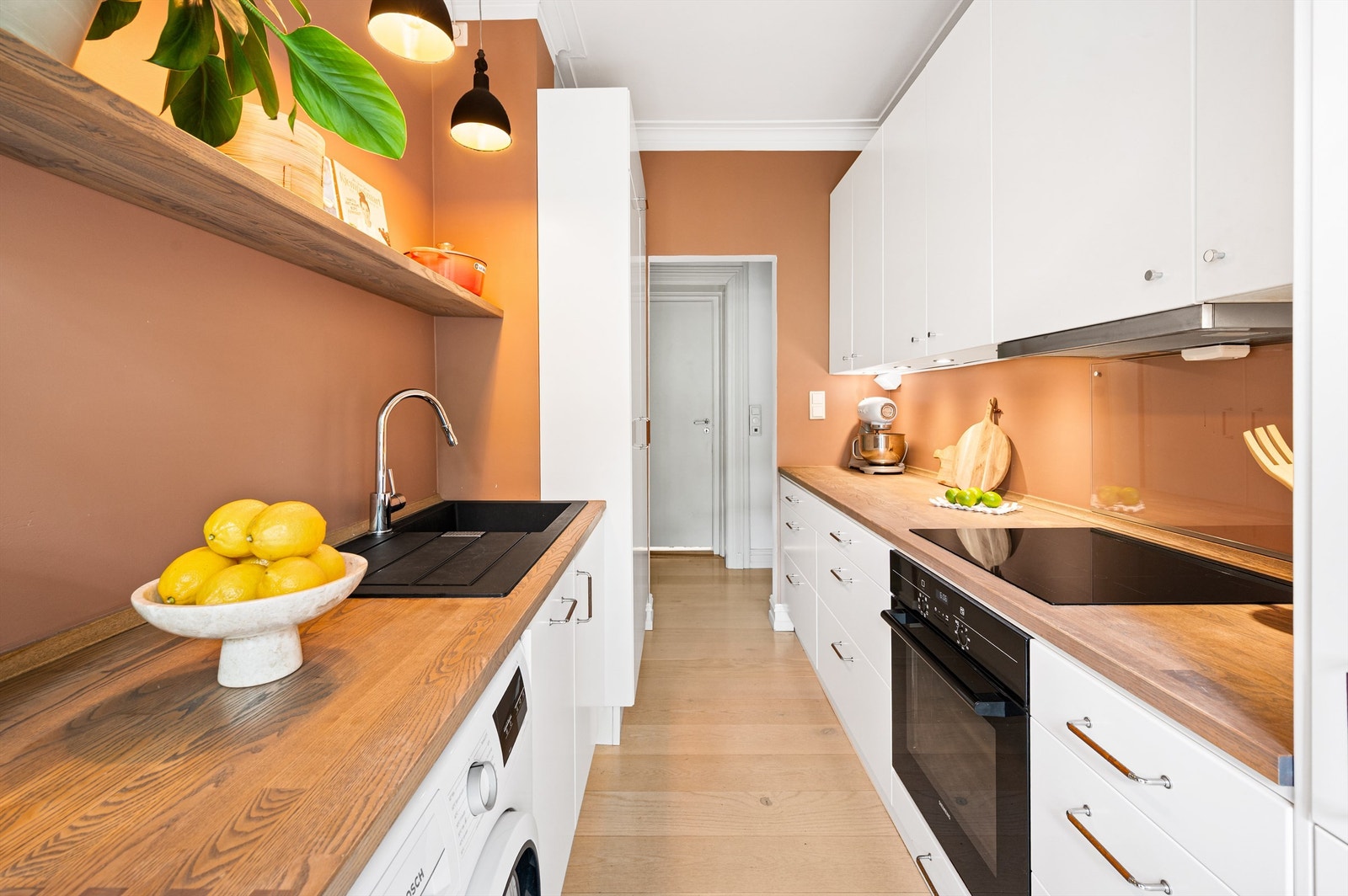 Lyst og romslig kjøkken som ligger i en separat løsning. Her er det god plass til oppbevaring av kjøkkenredskaper i over- og underskap samt gode arbeidsflater for matlaging på begge sider av rommet. Galleribilde