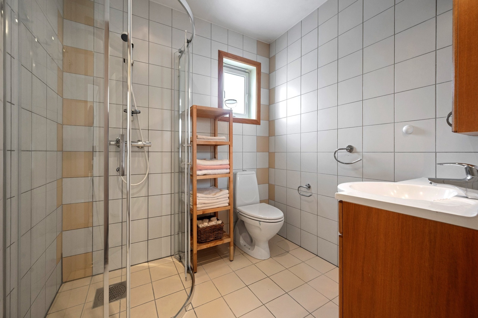 Helfliset bad med varmekabler i gulv. Servant med oppbevaring, speilskap på vegg, toalett, dusjkabinett. Varmekabler i gulv, spotter i tak. Galleribilde