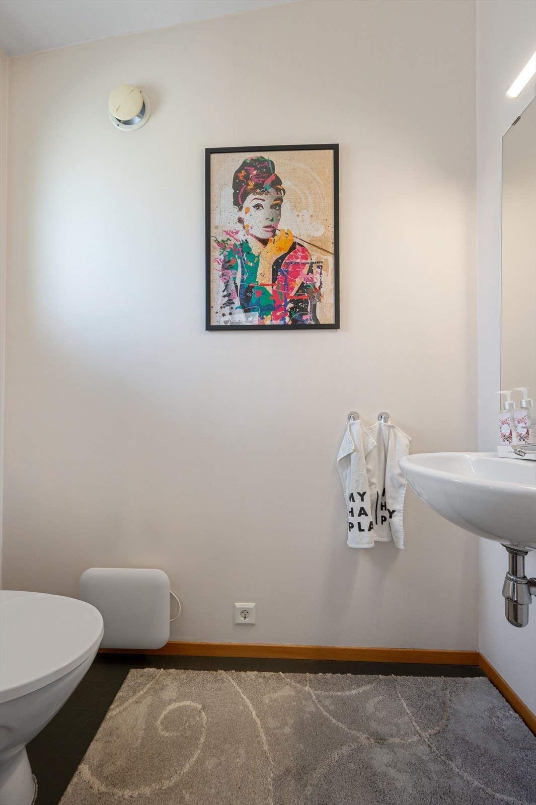 Wc med belegg på gulv, lyse vegger og enkel servant. Varmeovn. Galleribilde