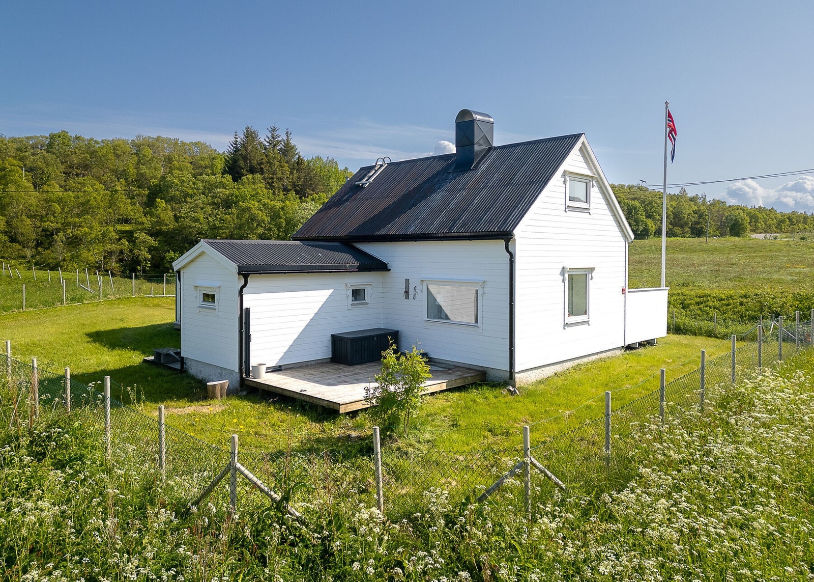 Hele eiendommen er gjerdet inn, og det er flaggstang. Galleribilde