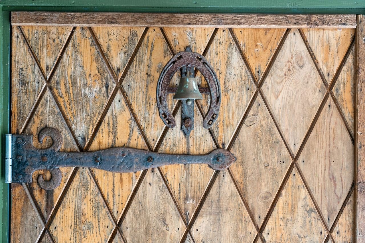 Unik heltre ytterdør med dekorative beslag understreker hyttas særpreg og sjel. Galleribilde