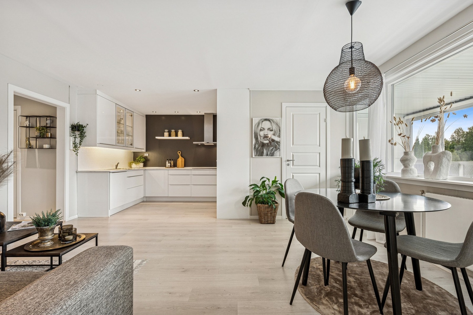 Åpen og luftig stue med plass til både sofagruppe og spisebord - i direkte tilknytning til det moderne kjøkkenet. Galleribilde