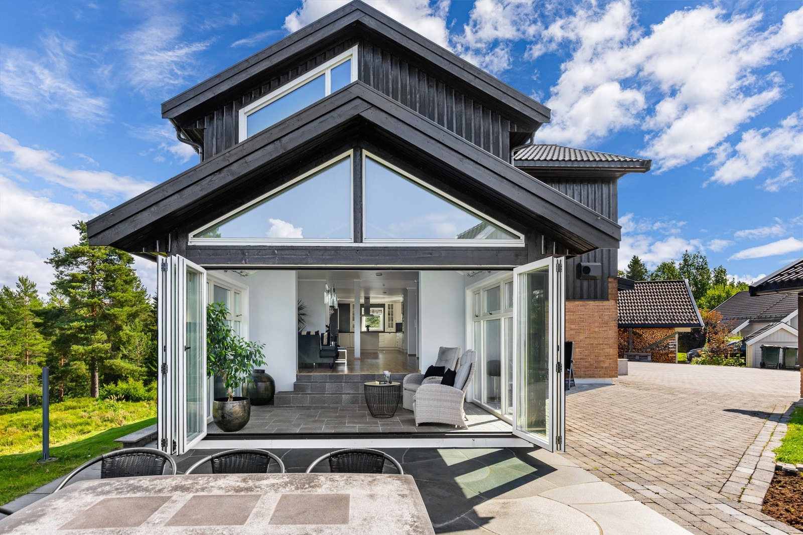 Uterommet skjermes av en bod, i tillegg til utrekkbare vegger. Her finner man roen med skogen som vakkert bakteppe, og uteplassen innredes enkelt med flere sittegrupper i ulike soner. Galleribilde