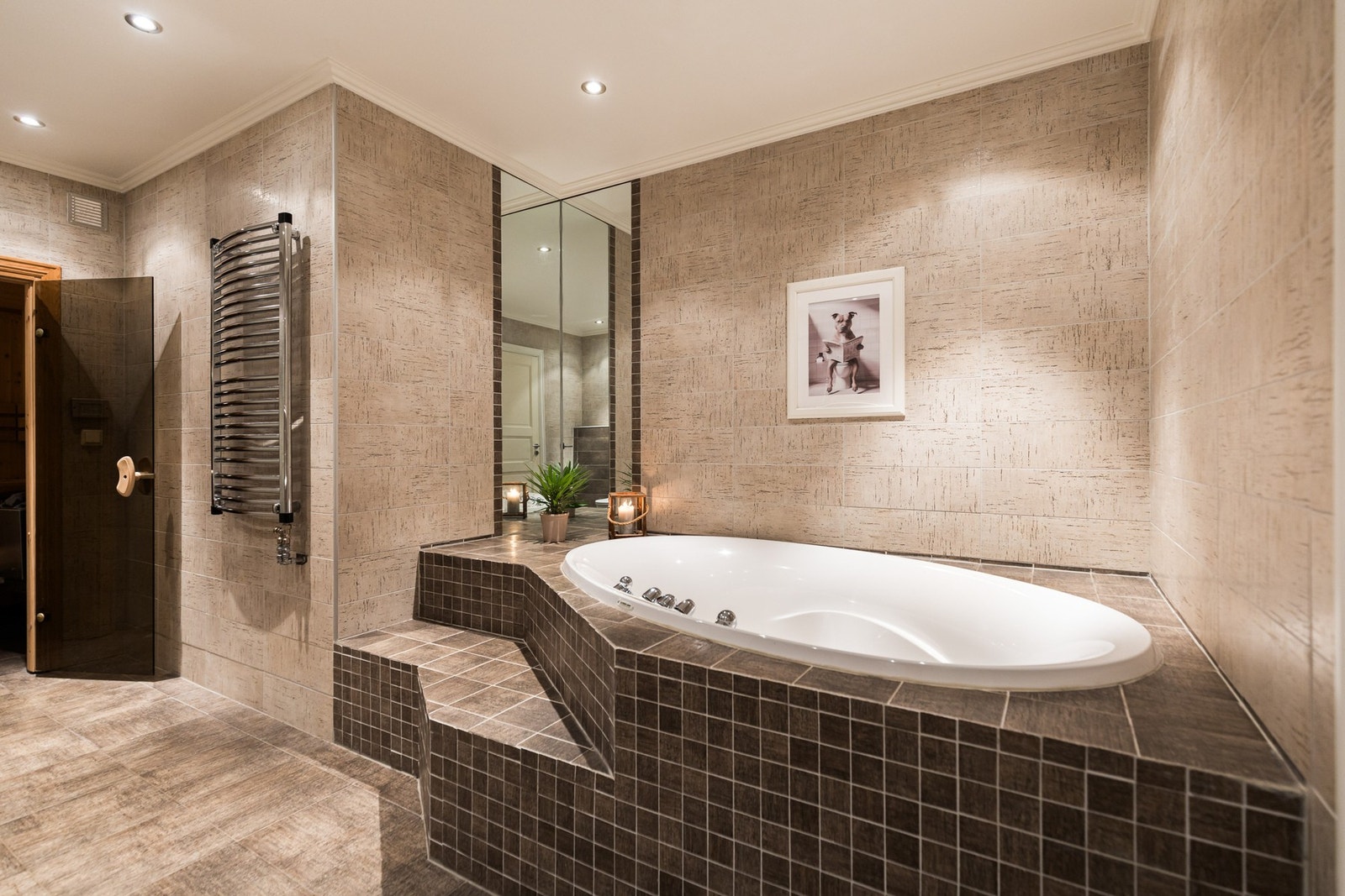 På badet er det både et dusjhjørne med innfellbare glassdører og et innfliset boblebadekar med plassbygd trapp. Galleribilde