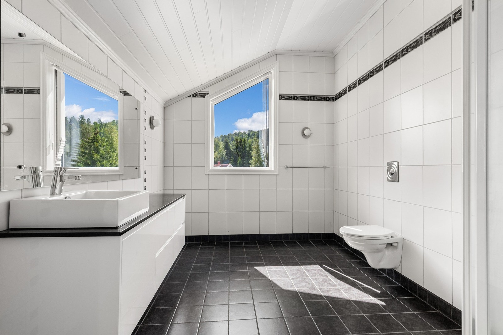 Planløsningen er praktisk, med toalett i alle etasjer. To bad er plassert på samme plan som soverommene, og boligen har et ekstra wc-rom ved hallen og to praktiske vaskerom - ett i underetasjen og ett på hovedplanet. Galleribilde