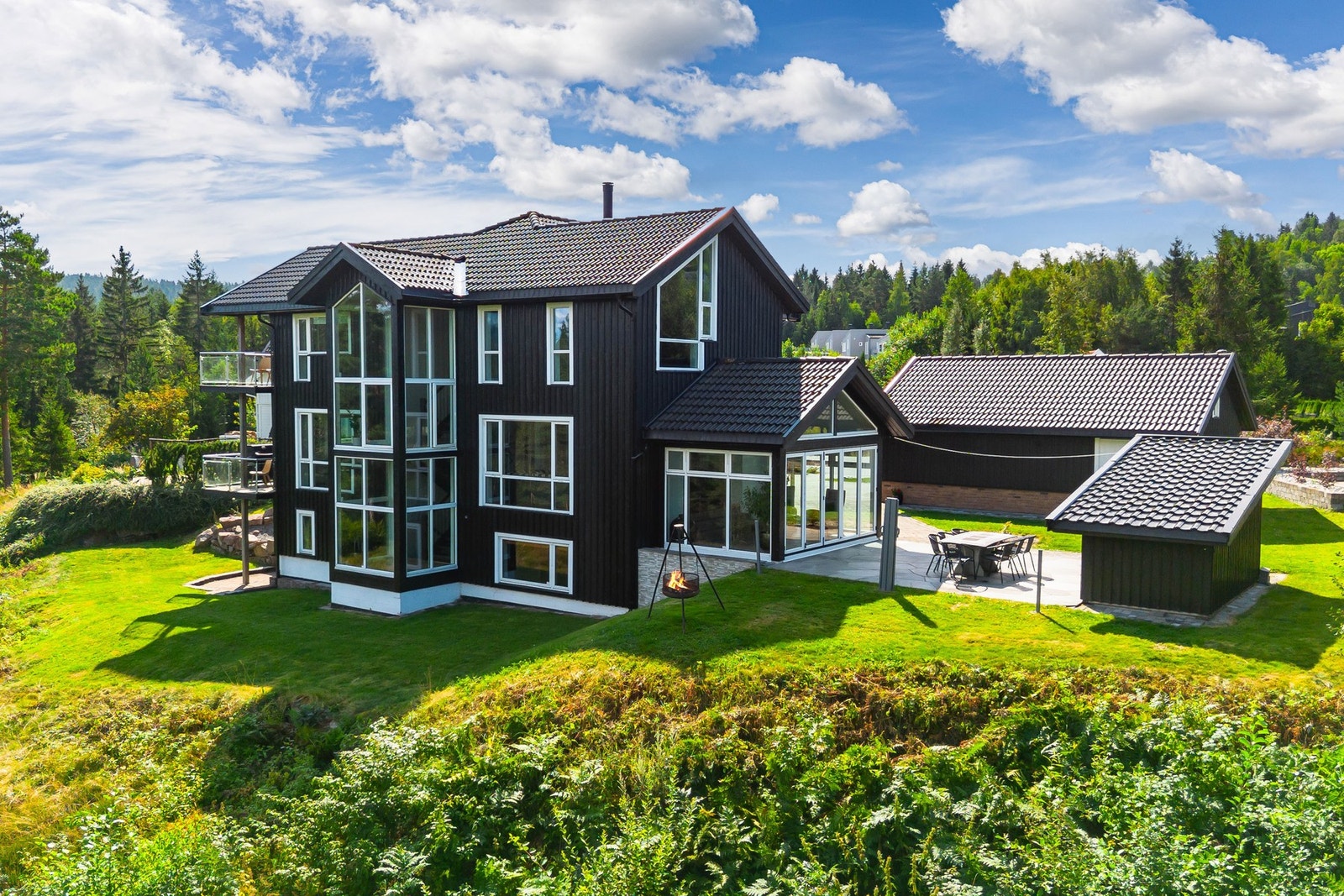 Bebyggelsen er gjennomført, kledd med teglstein og stilren kledning malt i sort. Galleribilde
