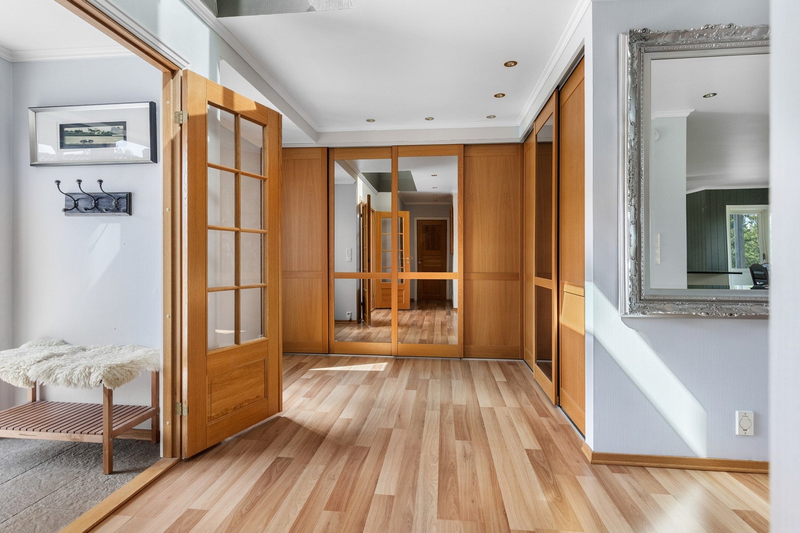 En tofløyet glassdør med rammer i eik tar deg videre inn til en stor hall med downlights og gjestetoalett, der plassen er godt utnyttet med et stort hjørneskap for yttertøyet. Galleribilde