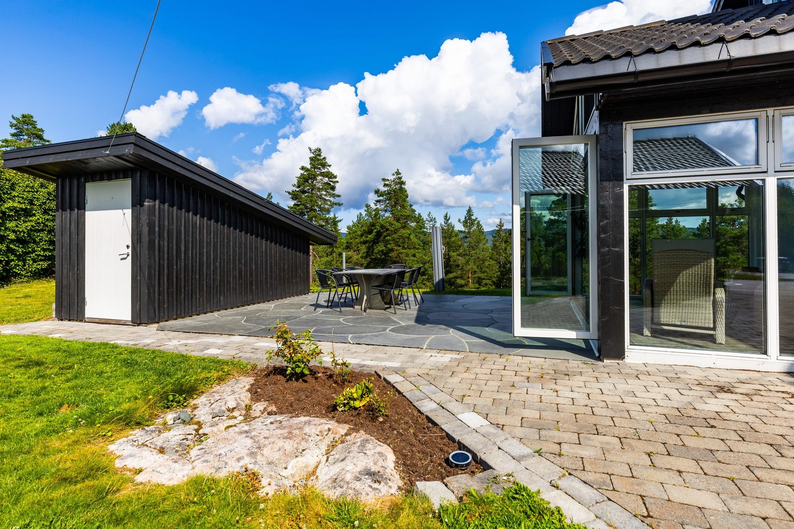Tomten gir et godt førsteinntrykk, pent opparbeidet med bed, stor gressplen, diverse beplantning og steinheller ved innkjørslen. Galleribilde