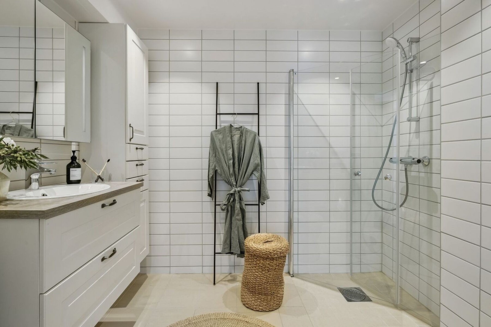 Baderommet fremstår som moderne og gjennomført, med fliser på både gulv og vegger samt behagelig gulvvarme for ekstra komfort. Galleribilde