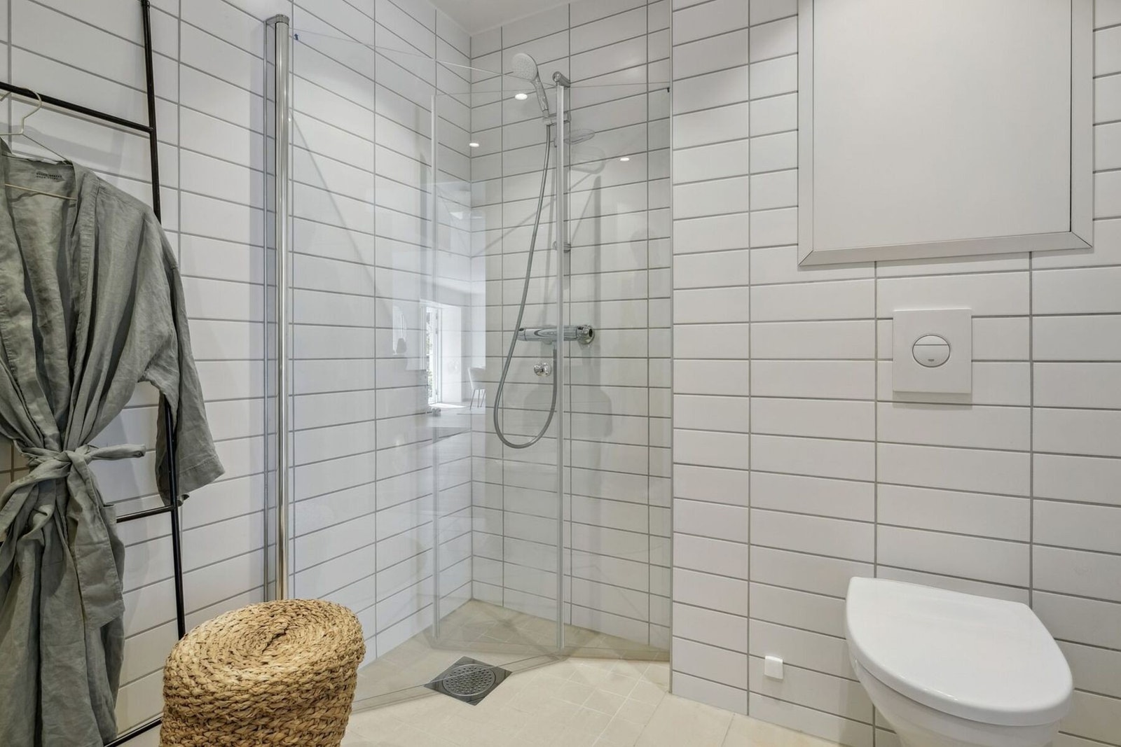 Innredningen består av servant med servantskap, veggmontert toalett med skjult sisterne og en praktisk hjørnedusj med innfellbare glassdører. Galleribilde