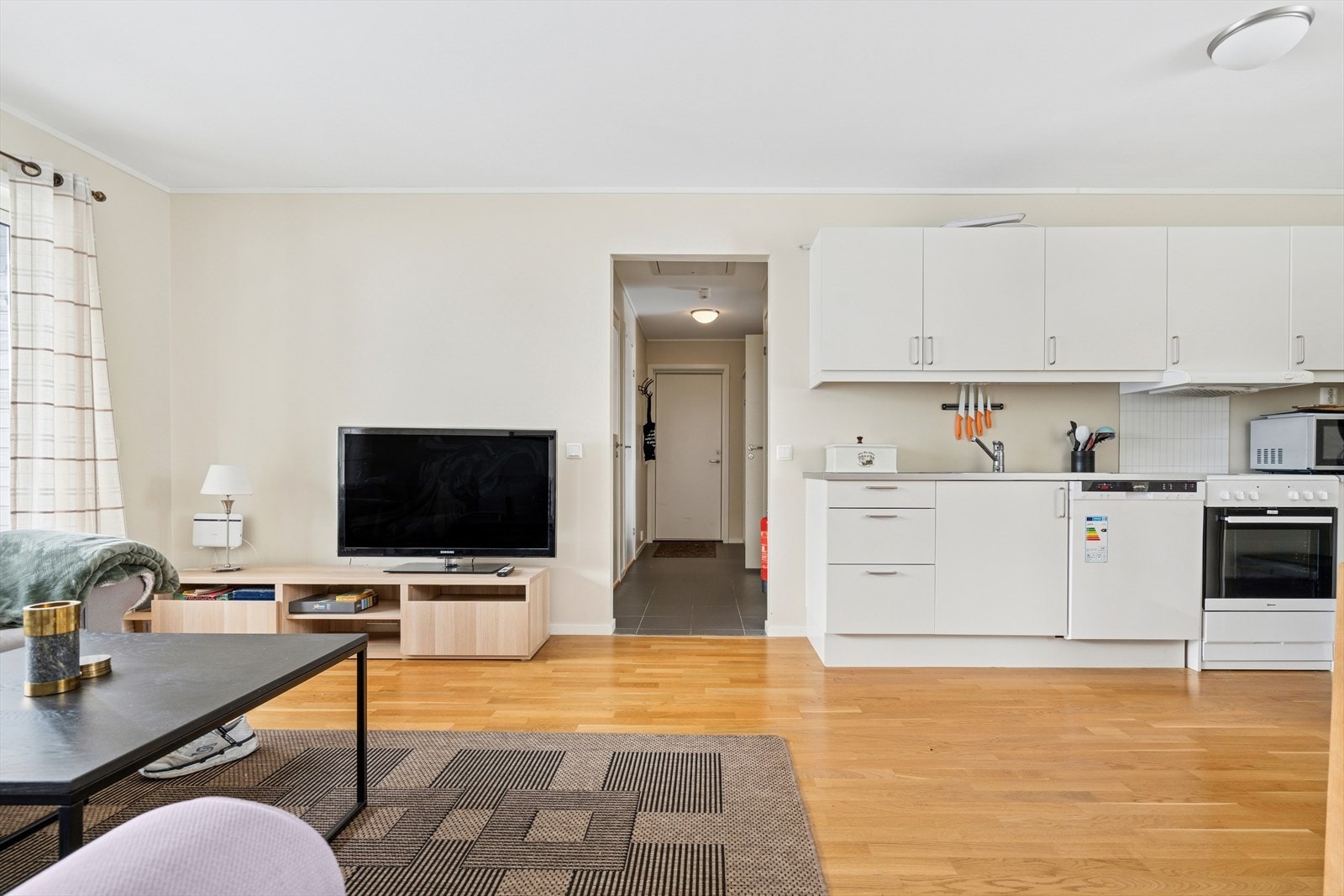 Stue/kjøkken er utført med parkettgulv og lysmalte overflater Galleribilde