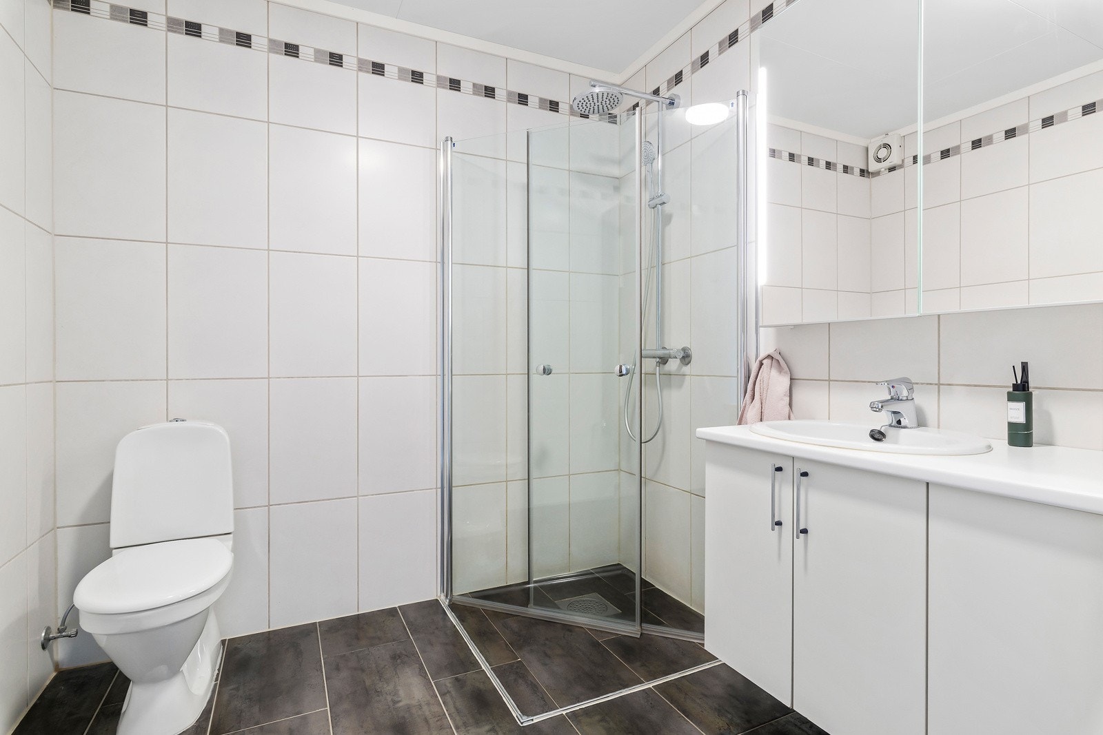 Innredningen har heldekkende servant og speil med lys på veggen. Galleribilde