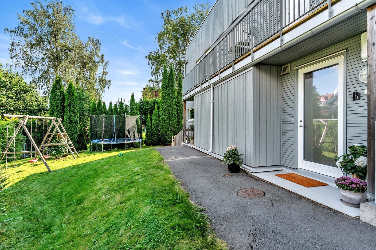 Ved boligens hovedinngang er en romslig plen som kun denne boligen har bruksretten til. Galleribilde