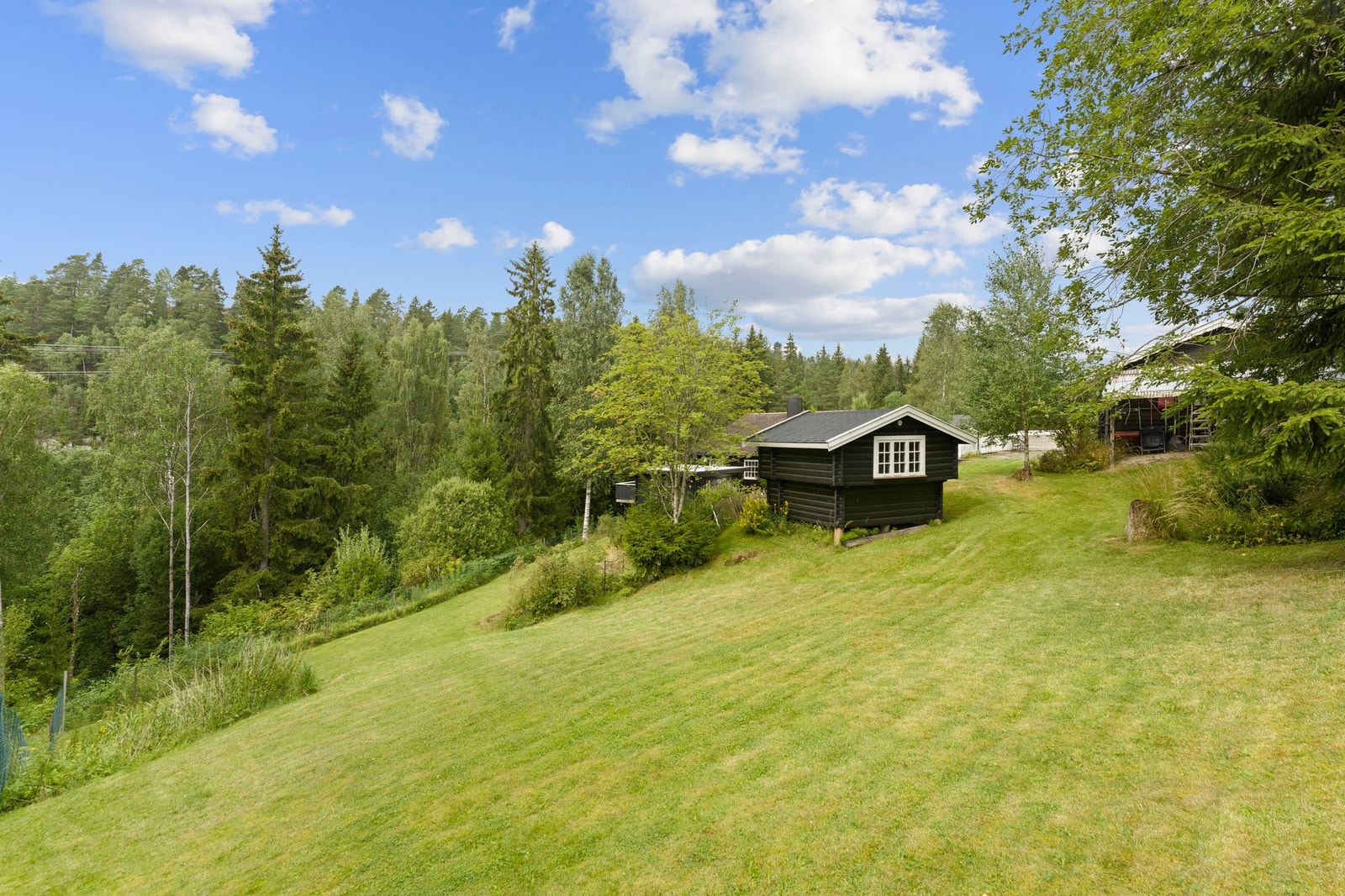 Eiendommen ligger på en stor tomt på over 2,3 mål, med plen, beplantning og god plass for både lek og dyrehold. Galleribilde