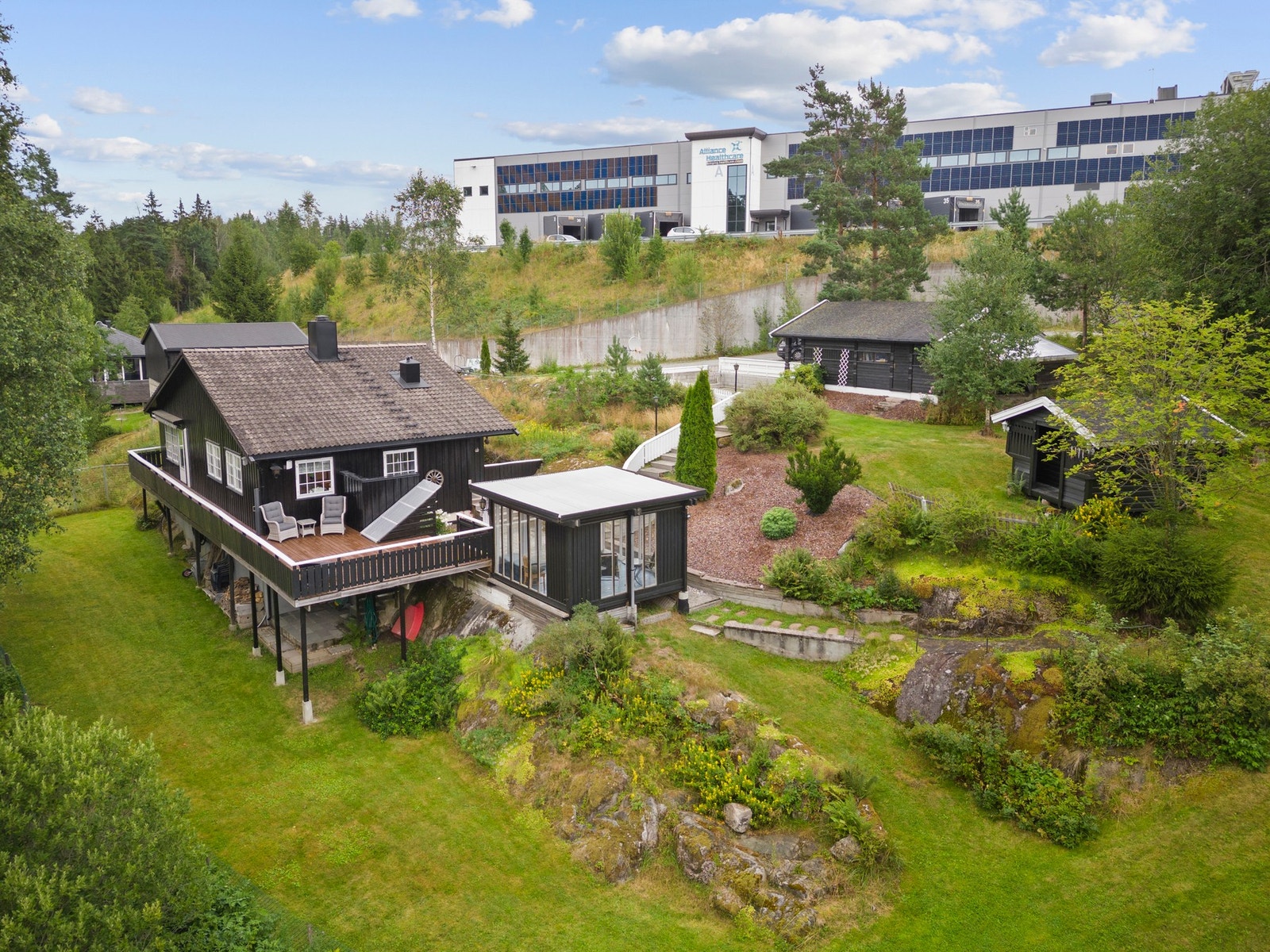 Her finner du en stor terrasse i impregnert treverk med rekkverk, i tillegg til en frittstående garasje, lysthus/paviljong og en enkel lekestue. Galleribilde