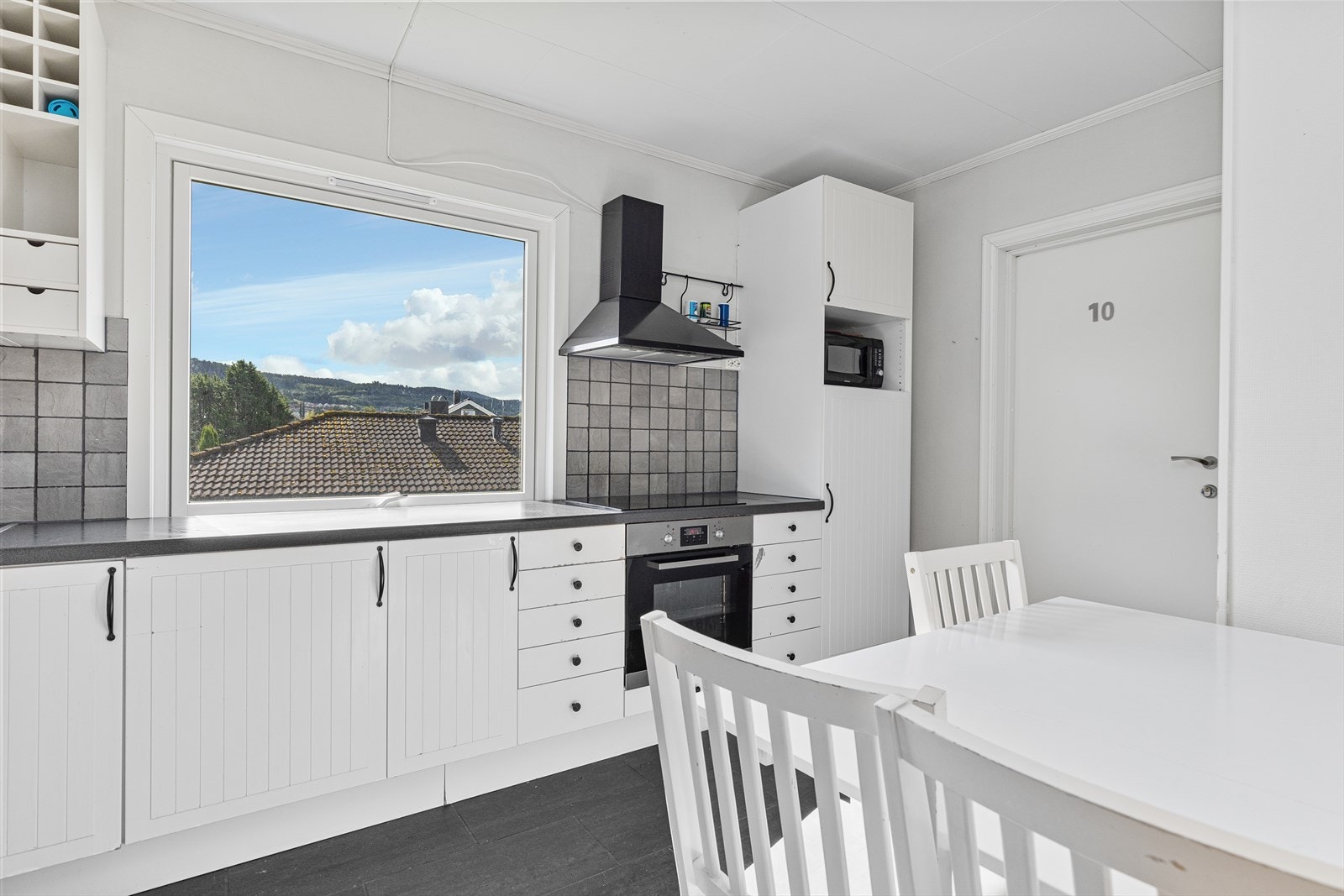 Kjøkkenet har integrert platetopp, stekeovn og oppvaskmaskin, samt ventilator over kokesone og nisje til kjøleskap. Galleribilde